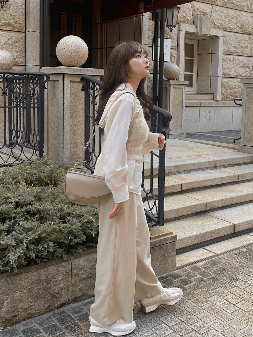 ホワイト系のスニーカー、ベージュ系のパンツ、ホワイト系のニット/セーターを着用したレディースの秋コーディネートの2枚目の写真