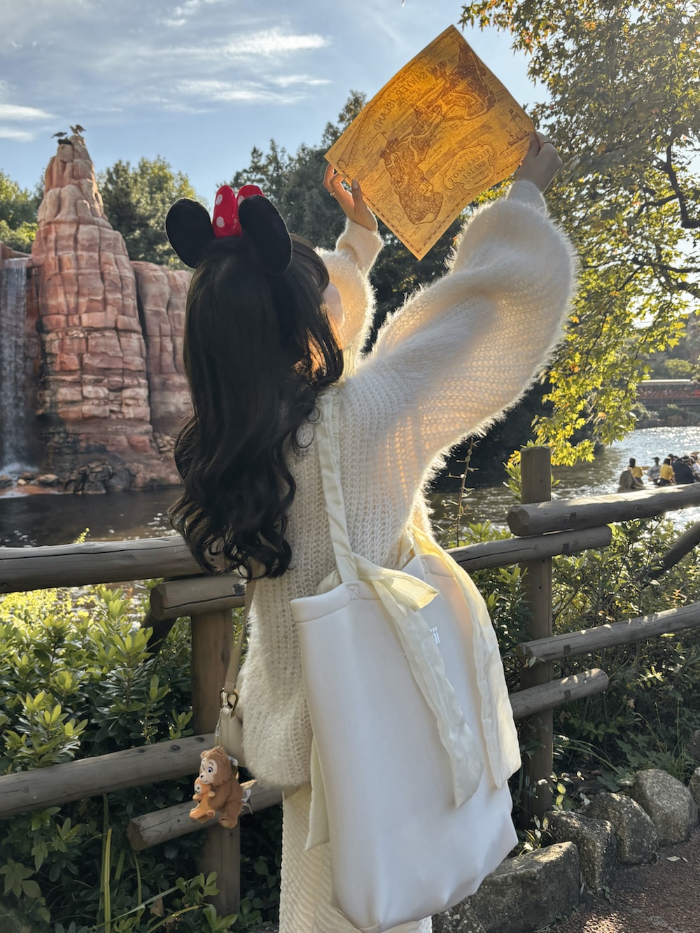 ホワイト系のトートバッグ、ホワイト系のスカート、ホワイト系のTシャツ/カットソーを着用したレディースの秋コーディネートの5枚目の写真