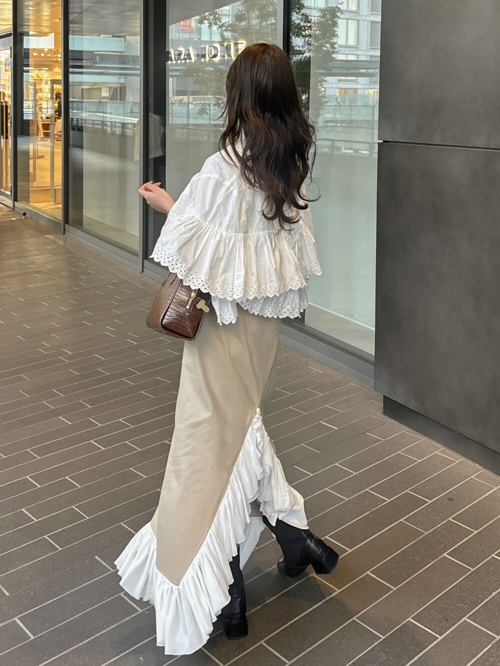 ベージュ系のスカート、ホワイト系のシャツ/ブラウス、ホワイト系のTシャツ/カットソーを着用したレディースの春コーディネートの4枚目の写真