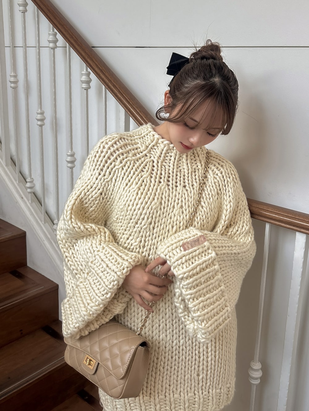 ホワイト系のトップス、ベージュ系のショルダーバッグ、ホワイト系のスカートを着用したレディースの冬コーディネートの3枚目の写真