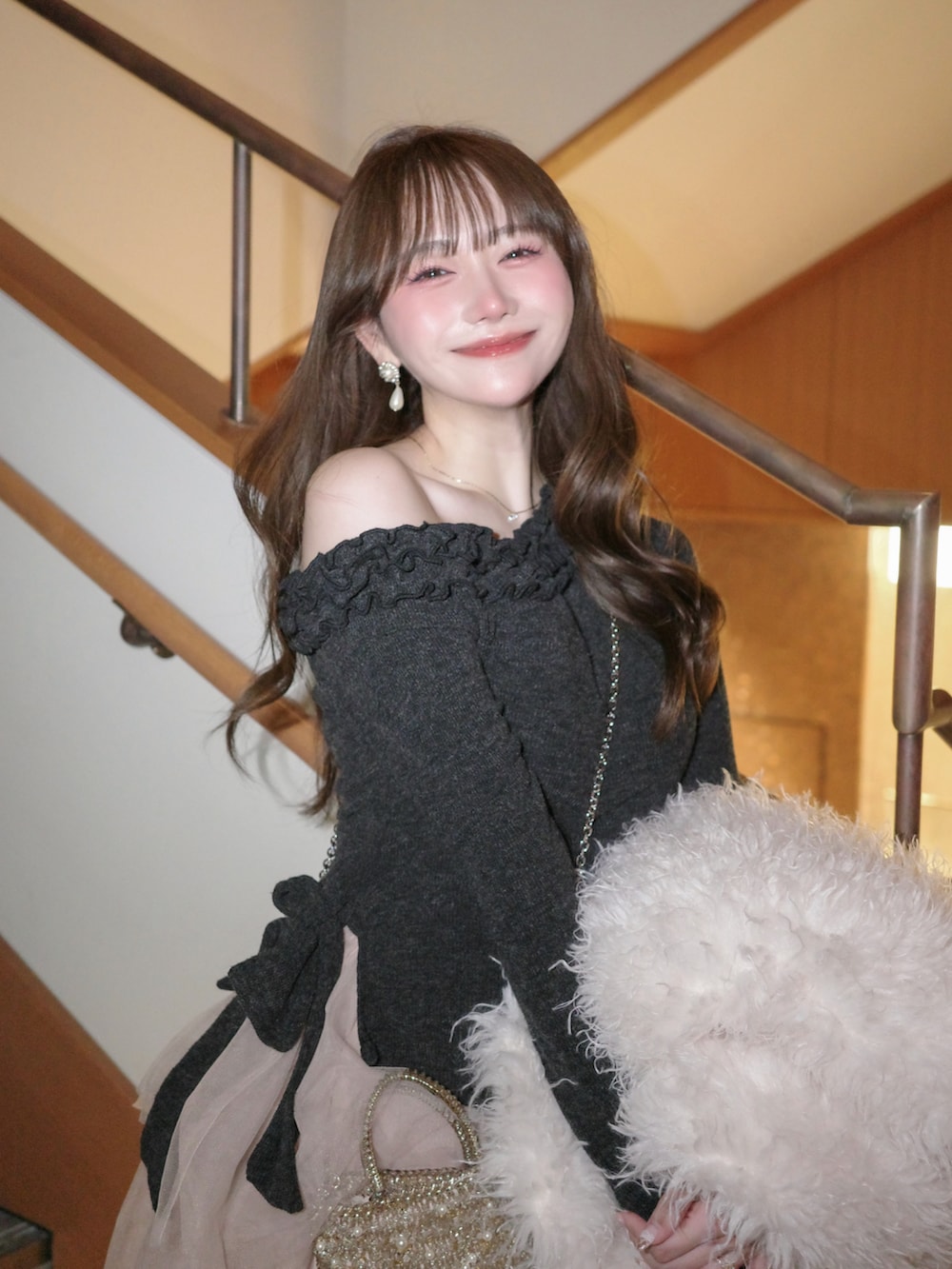 グレー系のシューズ、ピンク系のスカート、グレー系のセットアップを着用したレディースの冬コーディネートの4枚目の写真