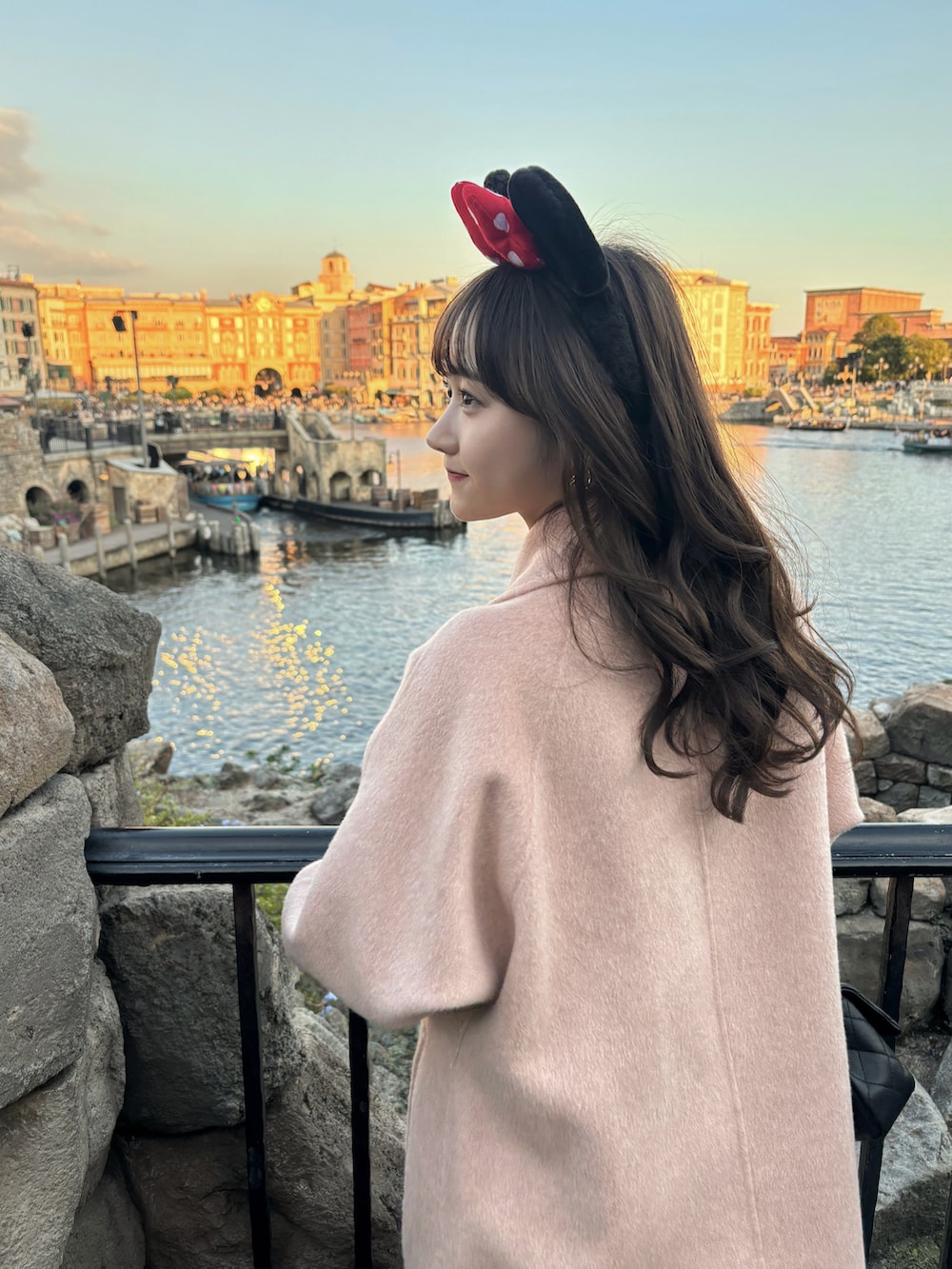 ピンク系のジャケット/アウター、ブラック系のバッグ、ホワイト系のニット/セーターを着用したレディースの秋コーディネートの5枚目の写真