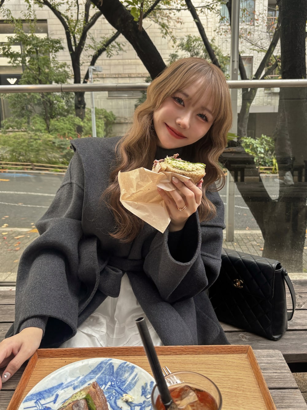 ブラック系のバッグ、ベージュ系のブーツ、グレー系のその他アウターを着用したレディースの秋コーディネートの3枚目の写真