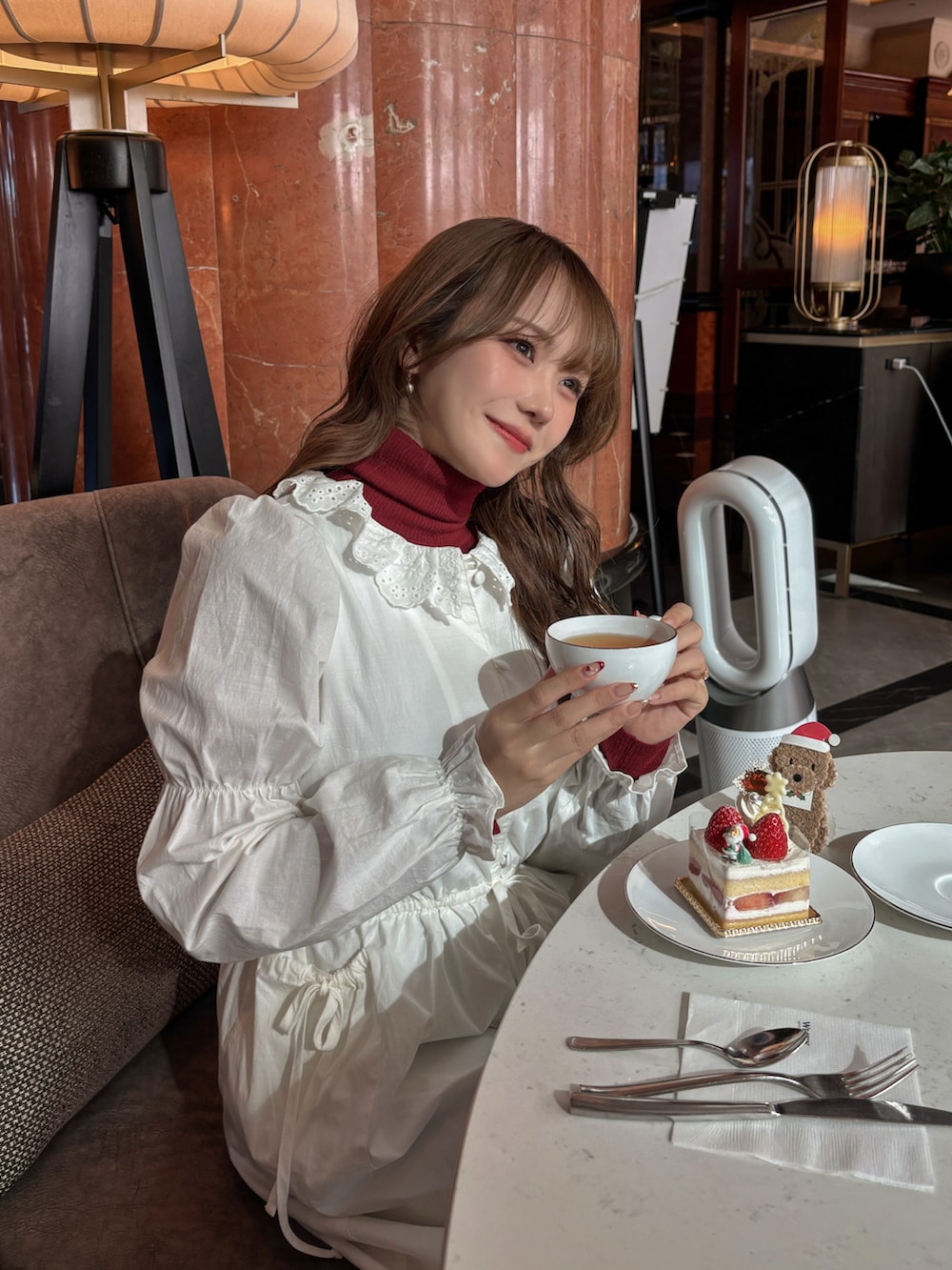 ホワイト系のワンピース、ホワイト系のその他アウター、レッド系のトップスを着用したレディースの冬コーディネートの3枚目の写真