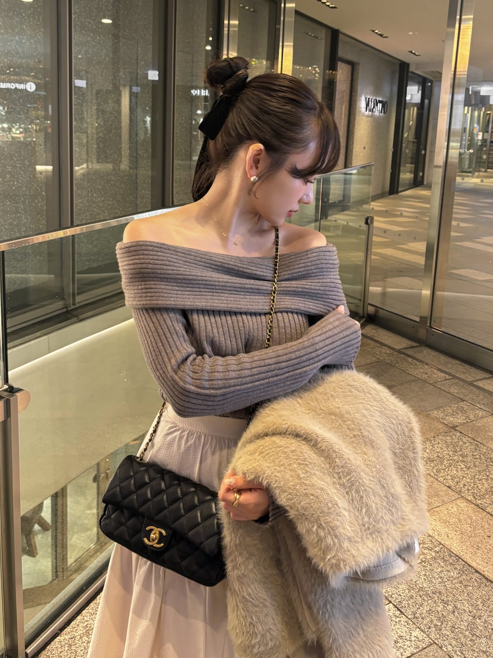 ホワイト系のスカート、ブラウン系のニット/セーター、ベージュ系のジャケット/アウターを着用したレディースの秋コーディネートの2枚目の写真