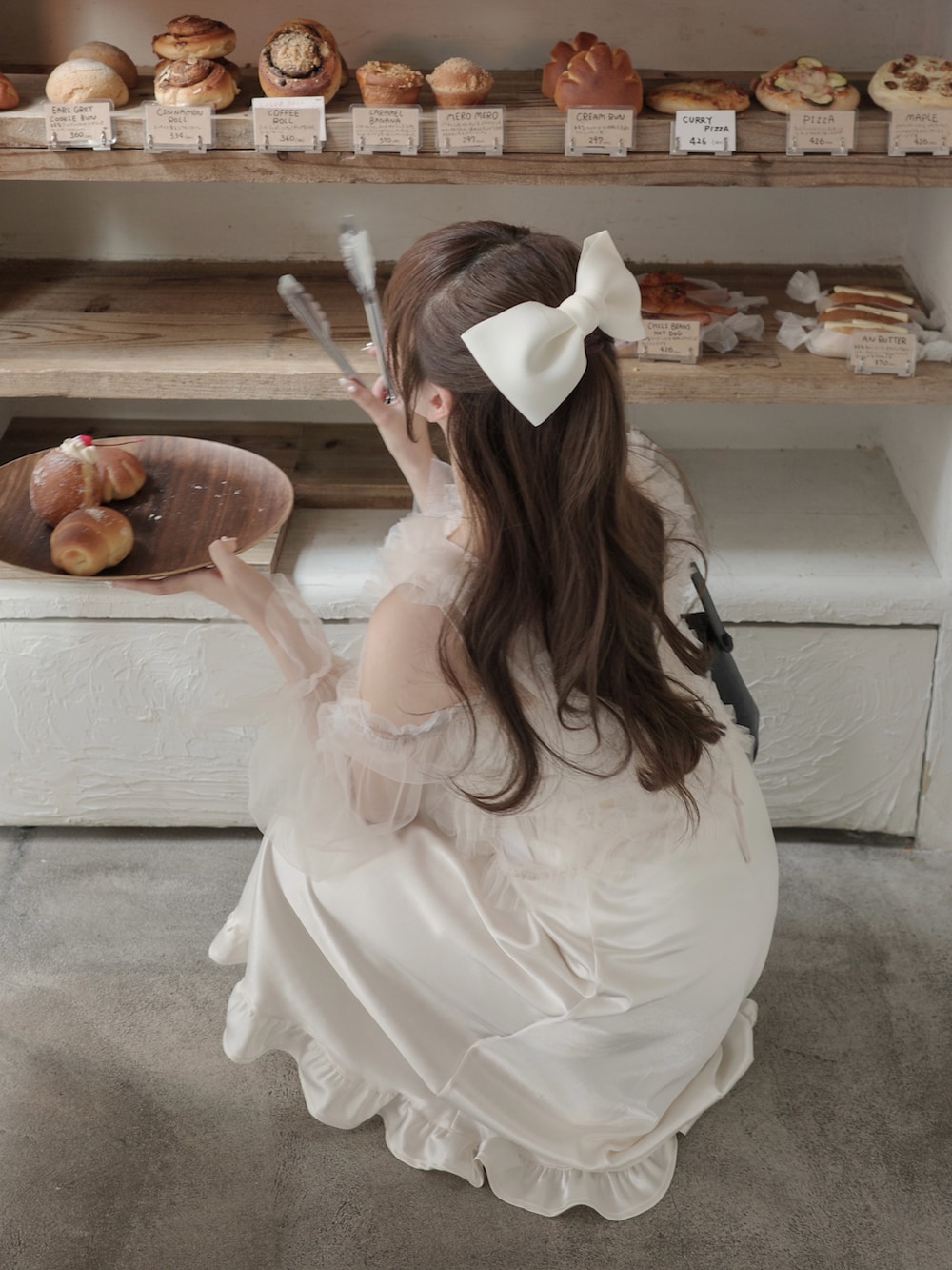 ブラック系のブーツ、ホワイト系のスカート、ホワイト系のトップスを着用したレディースの冬コーディネートの3枚目の写真