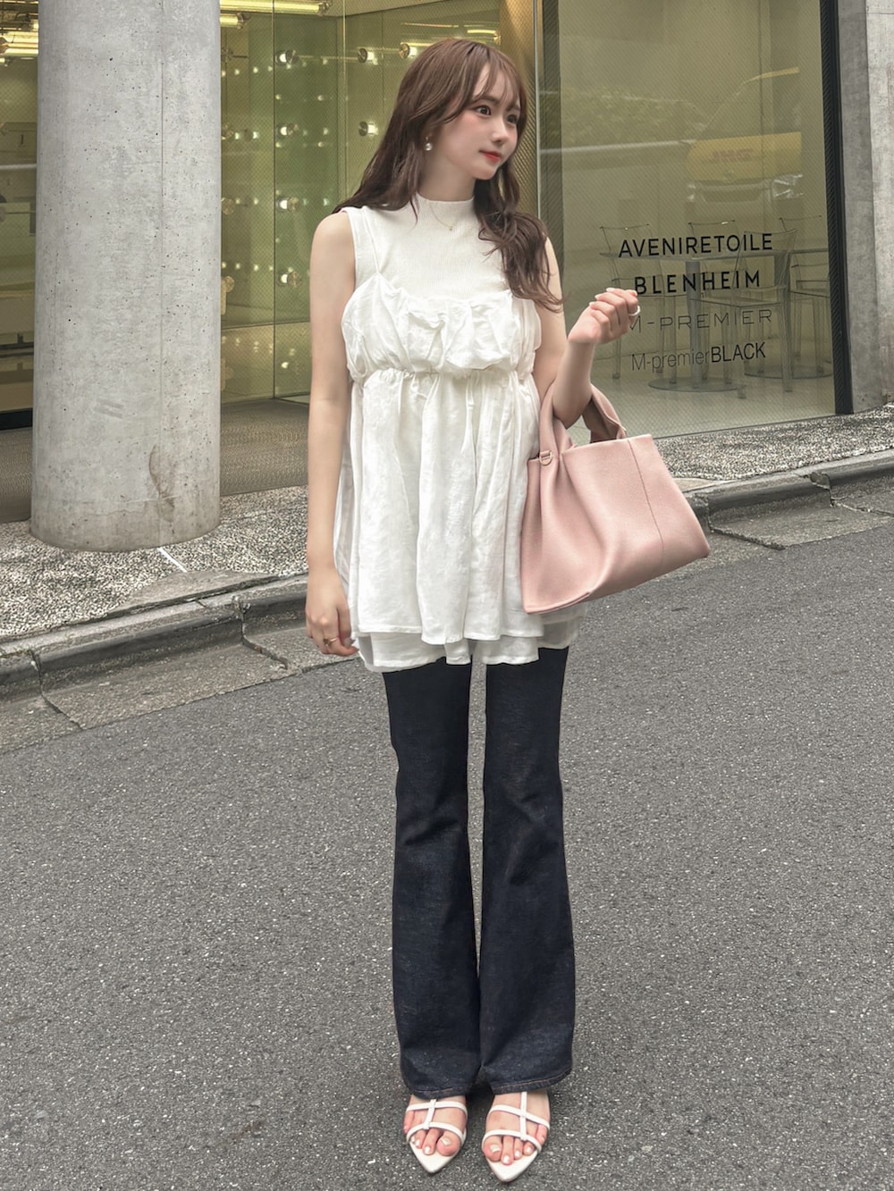 ブルー系のデニムパンツ、ホワイト系のニット/セーター、ホワイト系のキャミソールを着用したレディースの夏コーディネートの2枚目の写真