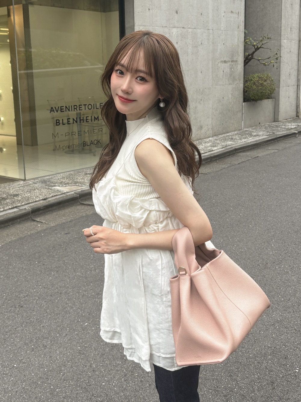 ブルー系のデニムパンツ、ホワイト系のニット/セーター、ホワイト系のキャミソールを着用したレディースの夏コーディネートの3枚目の写真