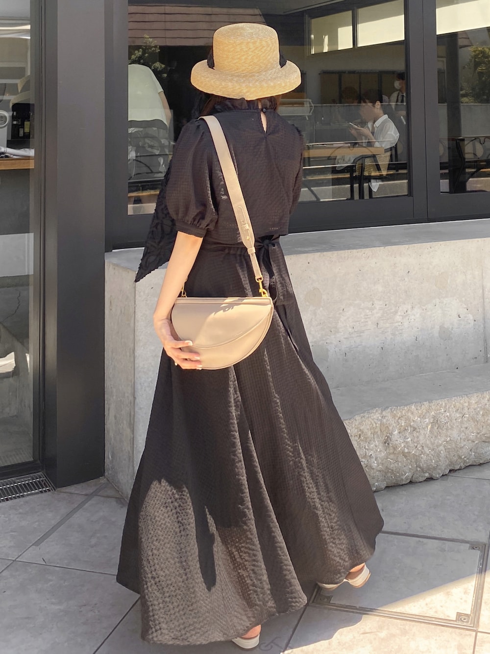 ベージュ系のバッグ、ホワイト系のサンダル、ブラック系のワンピースを着用したレディースの夏コーディネートの4枚目の写真