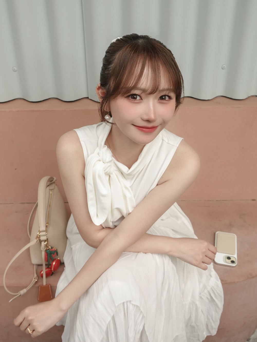 ホワイト系のスカート、ホワイト系のトップス、ベージュ系のバッグを着用したレディースの夏コーディネートの5枚目の写真