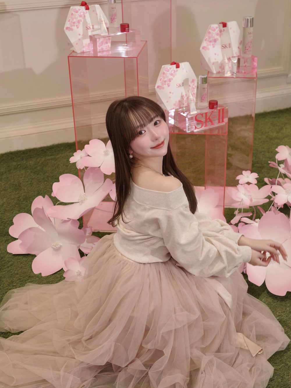 ピンク系のスカート、ベージュ系のスウェット、ホワイト系のバッグを着用したレディースの冬コーディネートの2枚目の写真