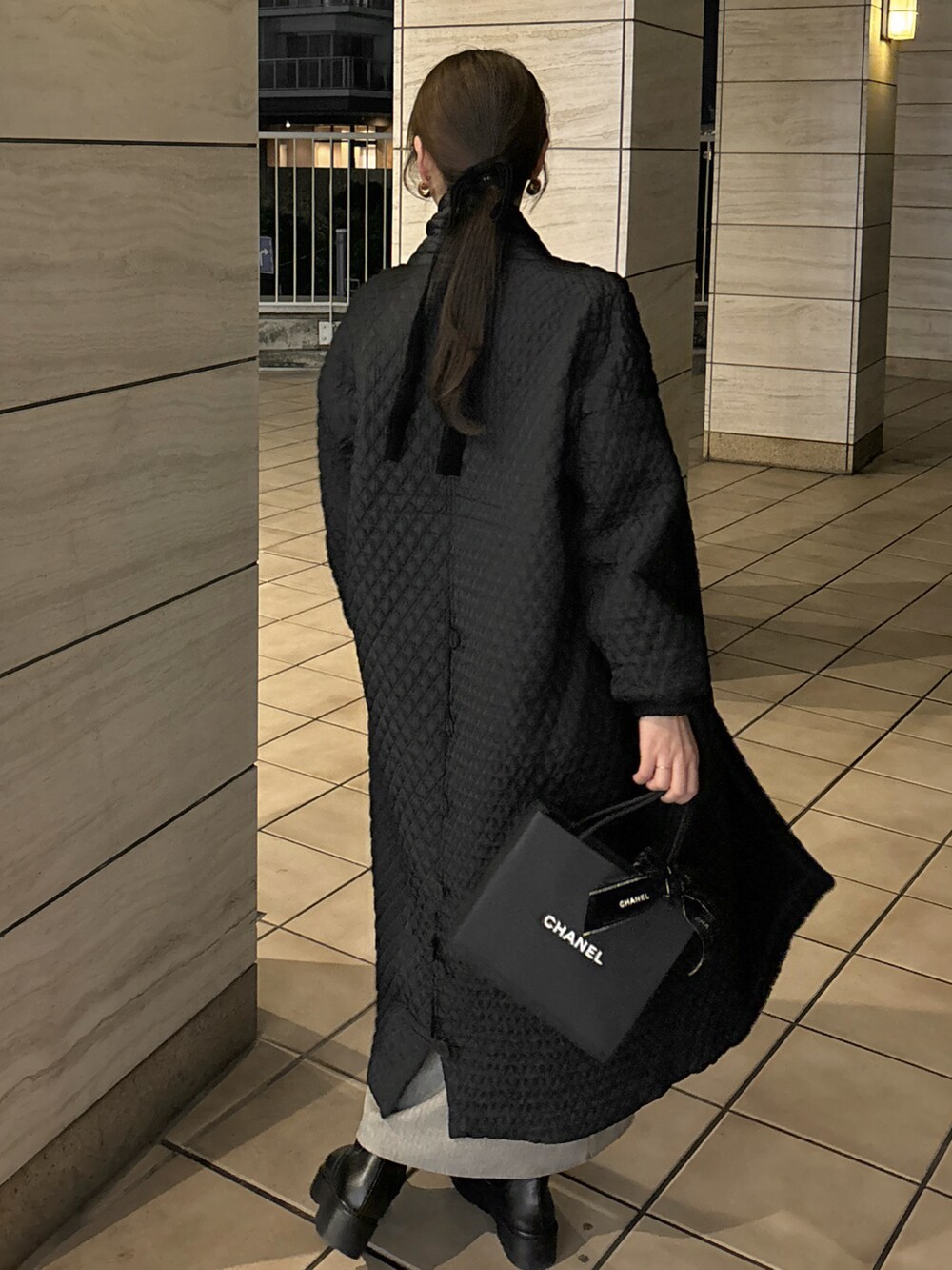 ブラック系のジャケット/アウター、レッド系のハンドバッグ、ホワイト系のニット/セーターを着用したレディースの冬コーディネートの2枚目の写真