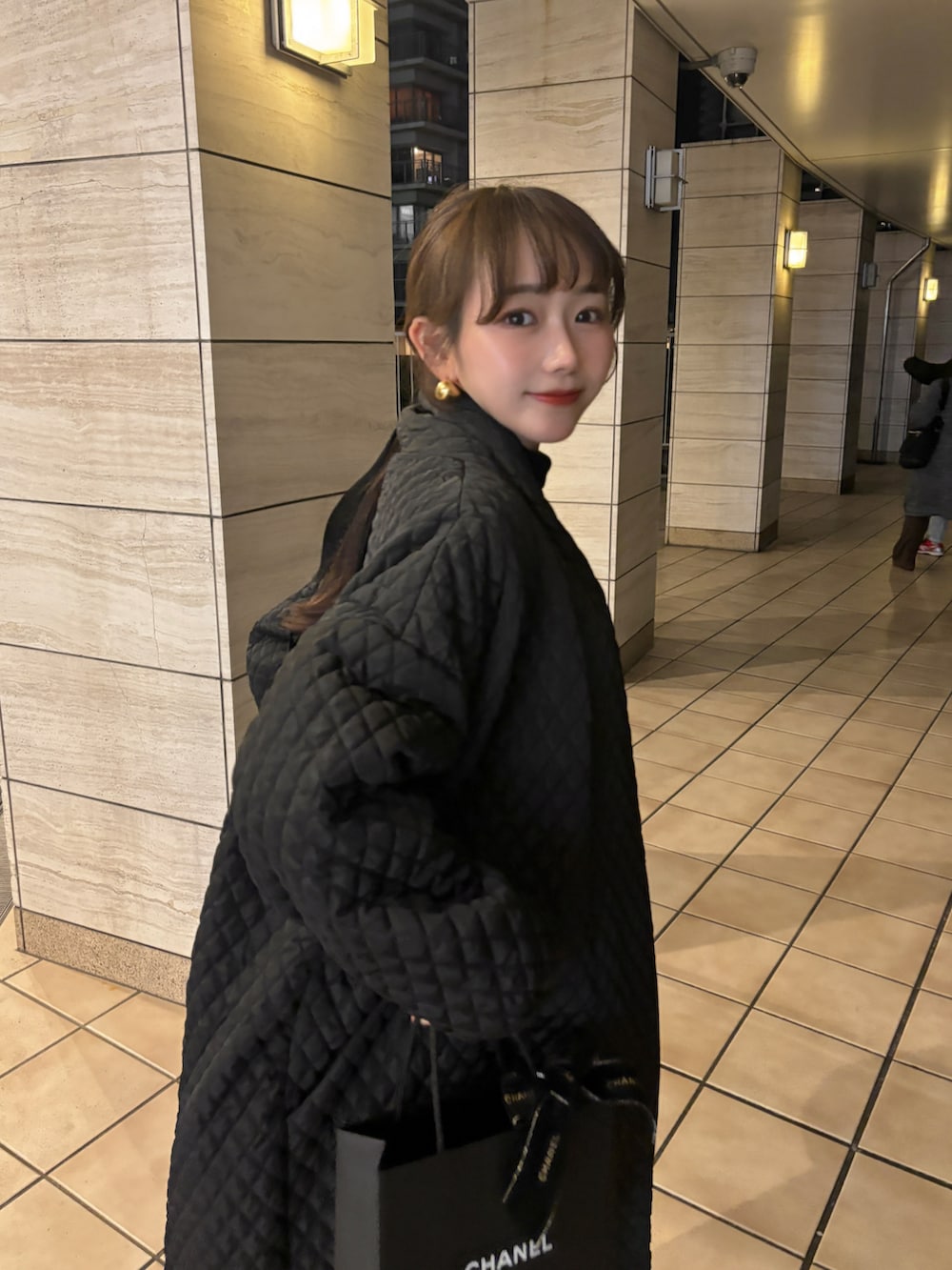 ブラック系のジャケット/アウター、レッド系のハンドバッグ、ホワイト系のニット/セーターを着用したレディースの冬コーディネートの4枚目の写真