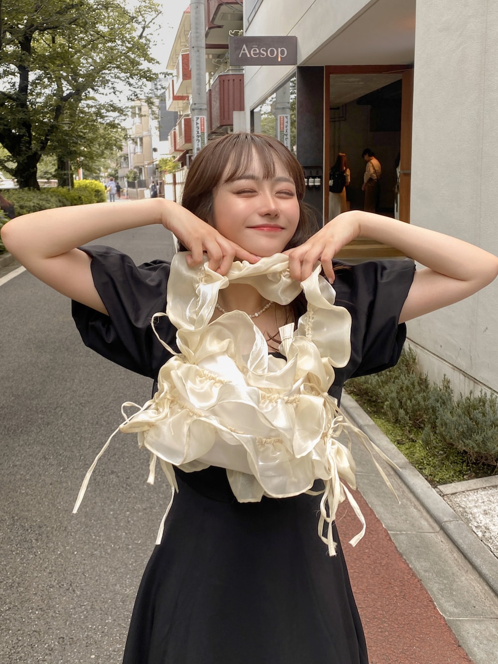 ブラック系のワンピース、ホワイト系のトートバッグを着用したレディースの夏コーディネートの3枚目の写真