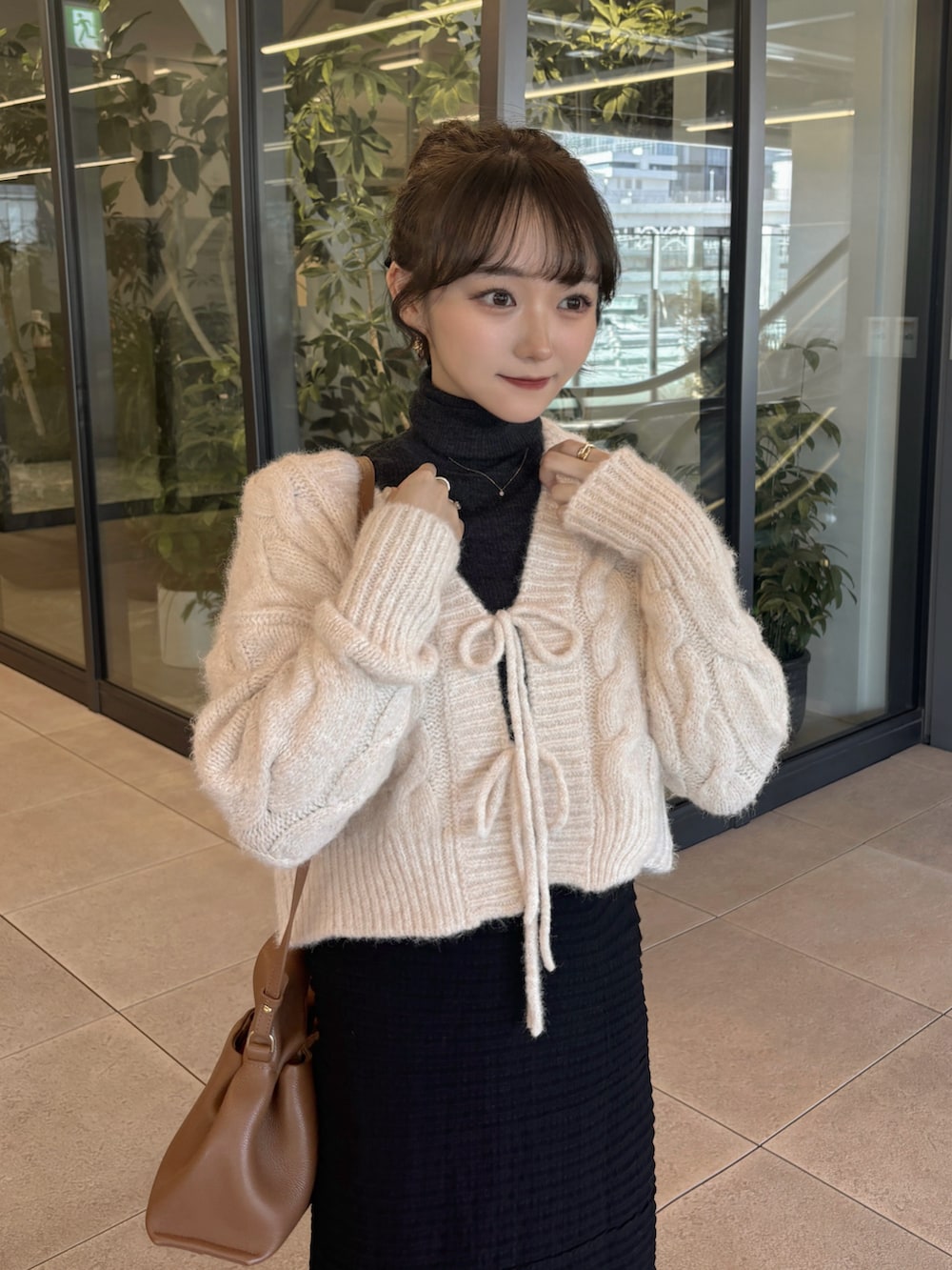 ホワイト系のニット/セーター、グレー系のトップス、ブラウン系のバッグを着用したレディースの秋コーディネートの4枚目の写真