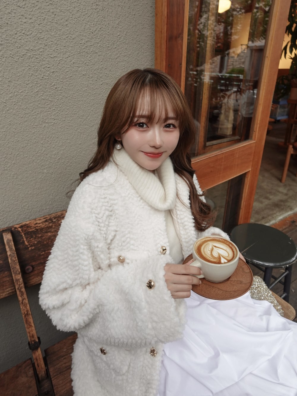 ホワイト系のブルゾン、ホワイト系のスカート、ブラック系のブーツを着用したレディースの秋コーディネートの4枚目の写真