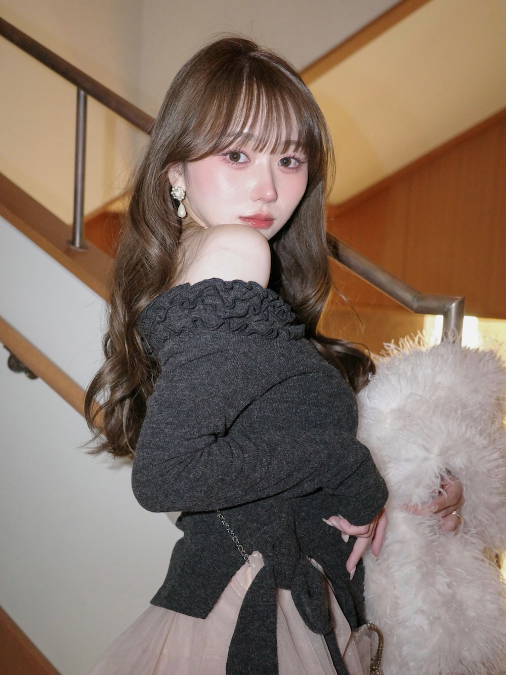 グレー系のシューズ、ピンク系のスカート、グレー系のセットアップを着用したレディースの冬コーディネートの3枚目の写真