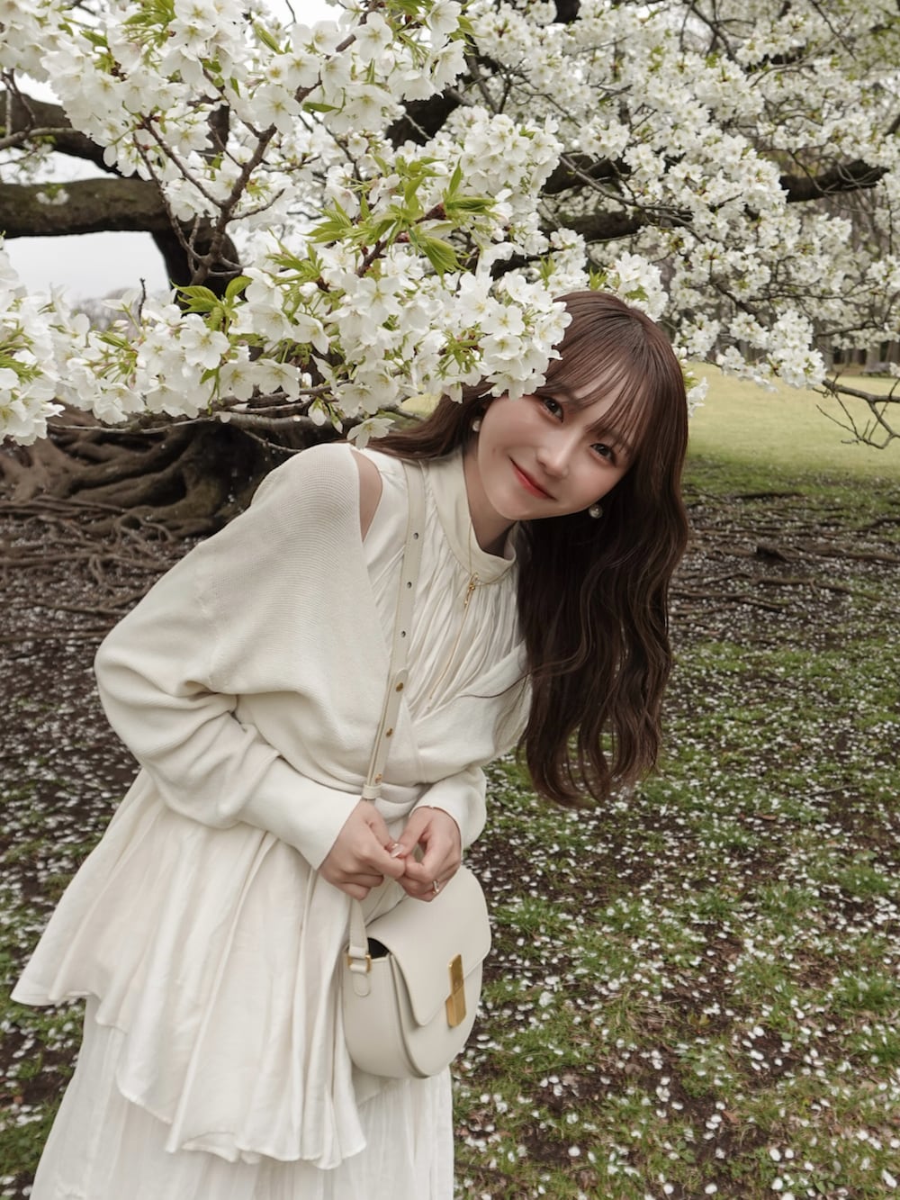 ホワイト系のスカート、ホワイト系のニット/セーター、ホワイト系のバッグを着用したレディースの春コーディネートの4枚目の写真