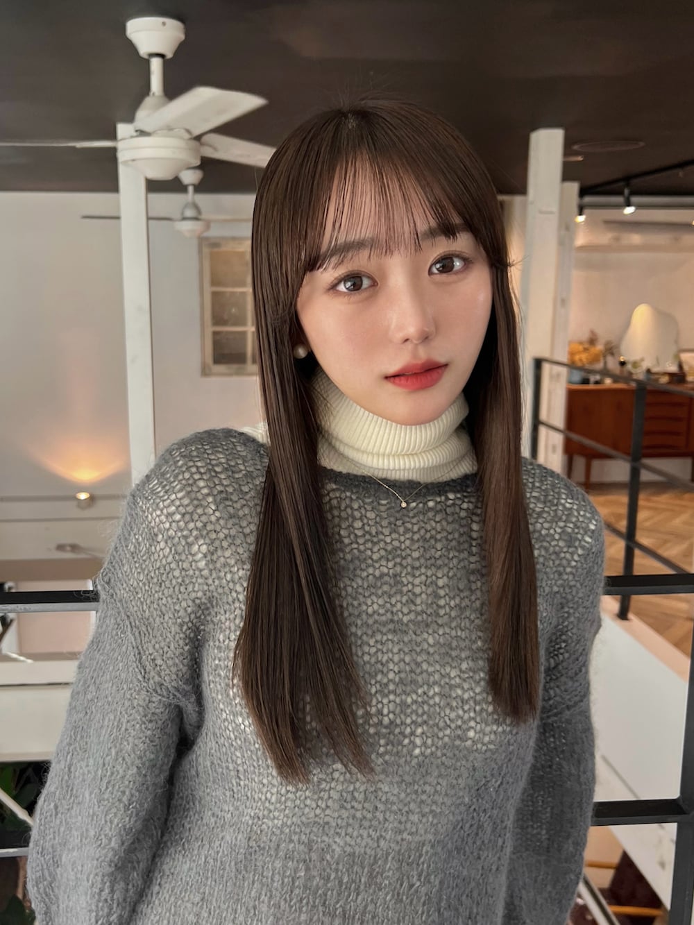 ホワイト系のダウンジャケット/コート、グレー系のニット/セーター、ホワイト系のニット/セーターを着用したレディースの冬コーディネートの2枚目の写真