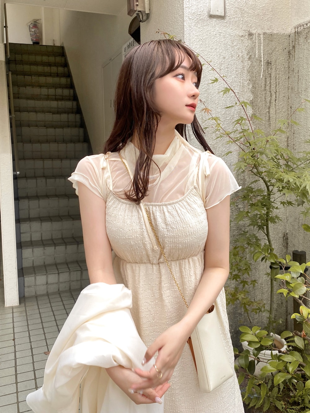 ホワイト系のショルダーバッグ、ホワイト系のシューズ、ホワイト系のシャツ/ブラウスを着用したレディースの夏コーディネートの4枚目の写真