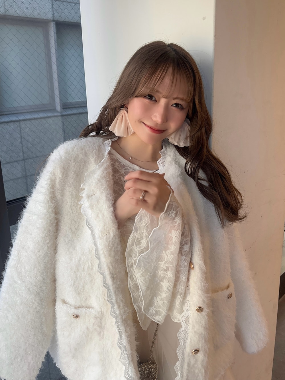 ホワイト系のノーカラージャケット、ホワイト系のシャツ/ブラウス、ホワイト系のスカートを着用したレディースの冬コーディネートの3枚目の写真