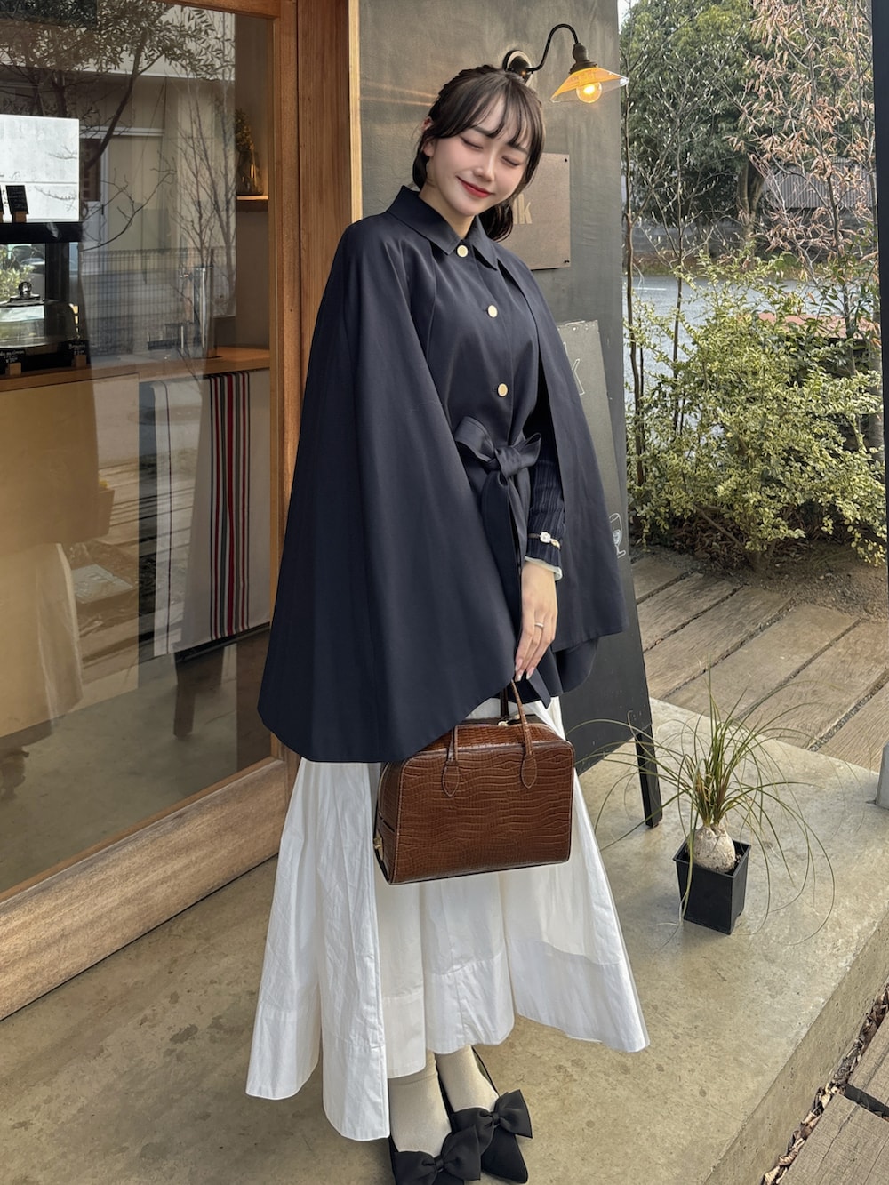 ブルー系のその他アウター、ホワイト系のスカート、ブラウン系のバッグを着用したレディースの春コーディネートの3枚目の写真