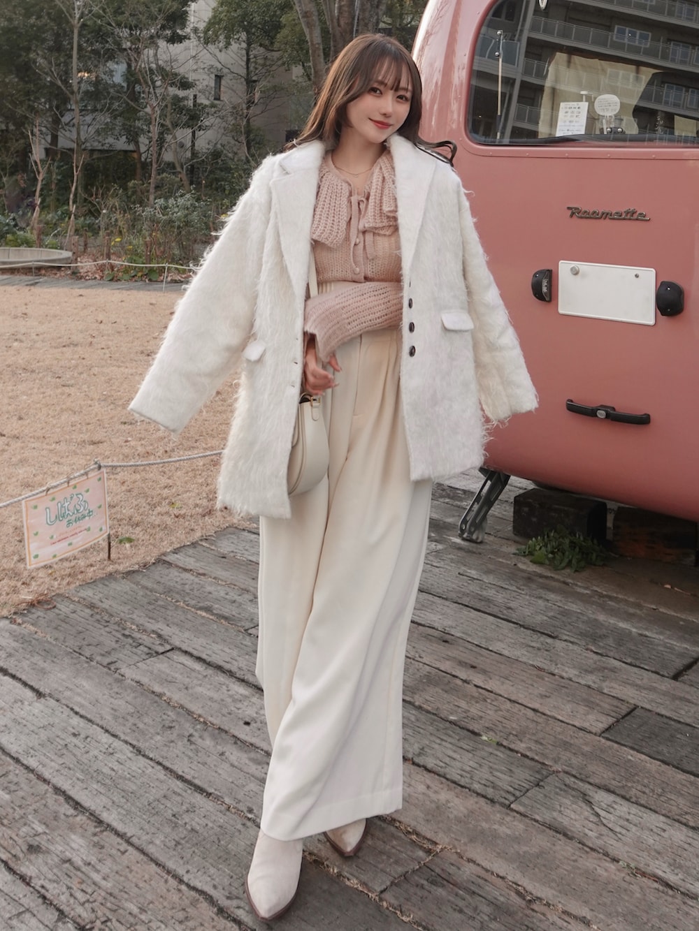 ホワイト系のスラックス、ホワイト系のピーコート、ピンク系のニット/セーターを着用したレディースの春コーディネートの2枚目の写真
