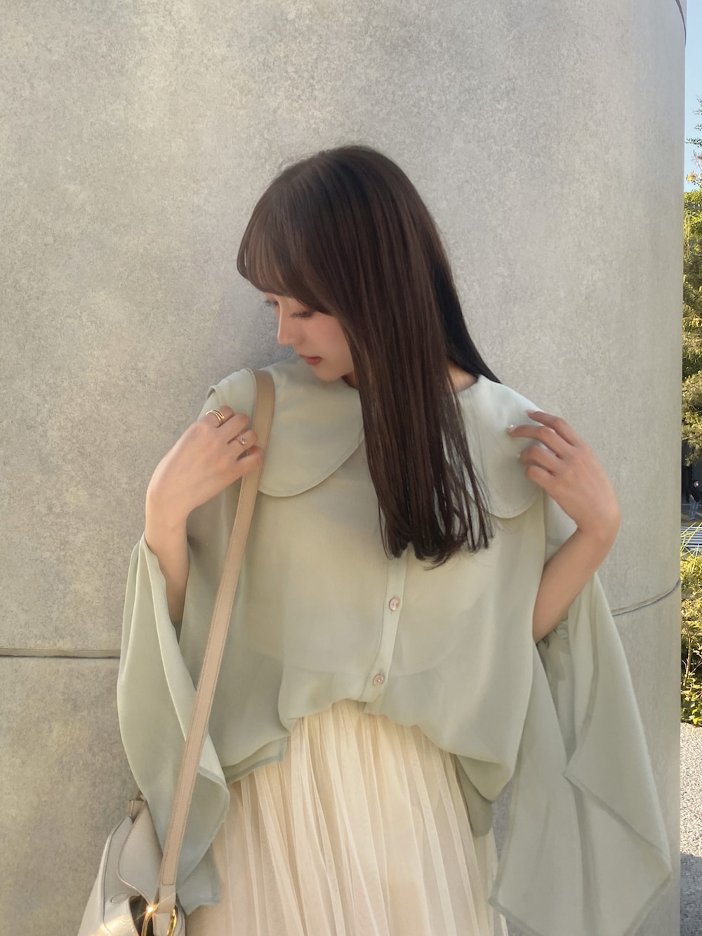 ベージュ系のスカート、ホワイト系のショルダーバッグ、ホワイト系のサンダルを着用したレディースの夏コーディネートの2枚目の写真