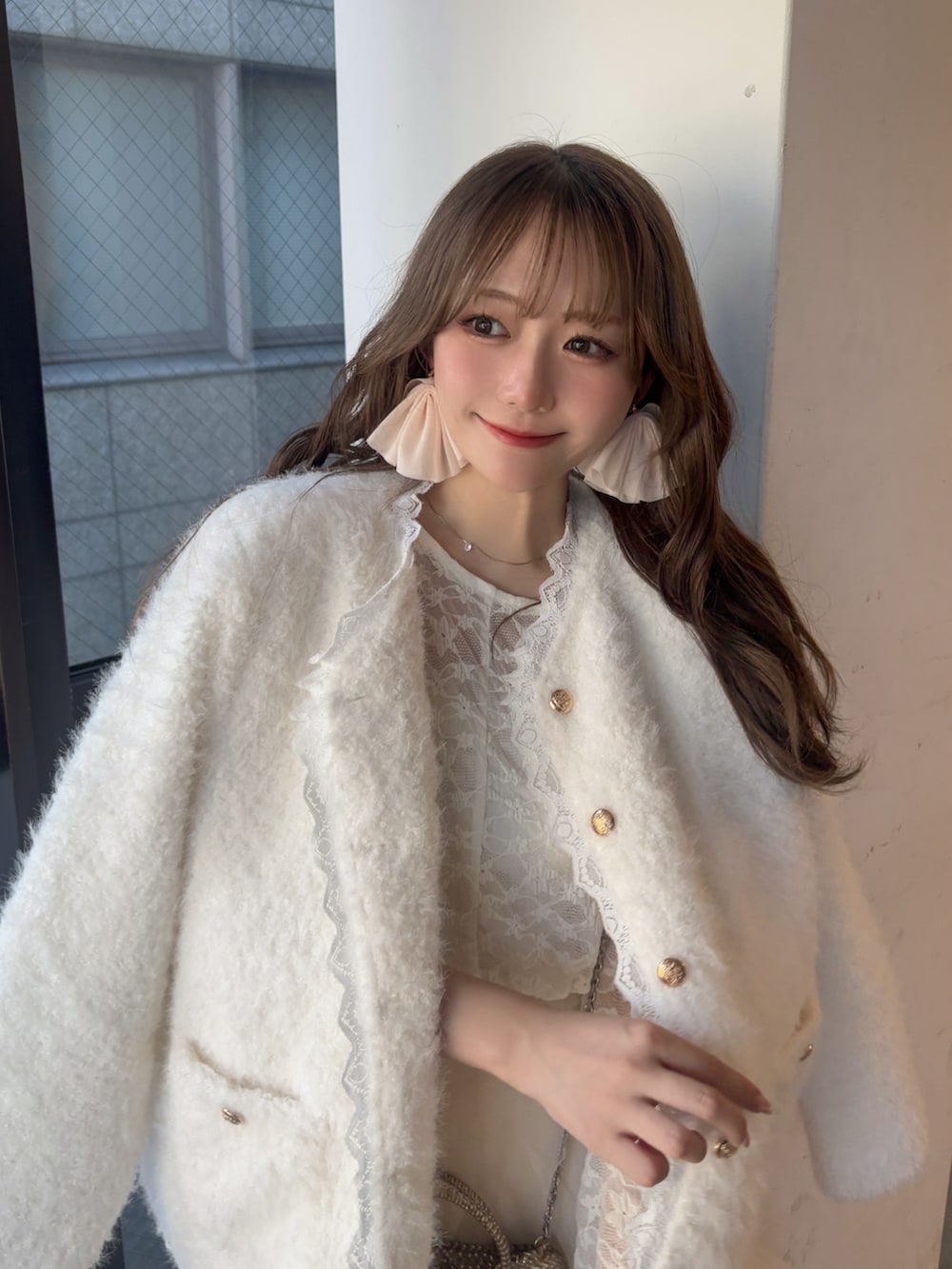 ホワイト系のノーカラージャケット、ホワイト系のシャツ/ブラウス、ホワイト系のスカートを着用したレディースの冬コーディネートの2枚目の写真