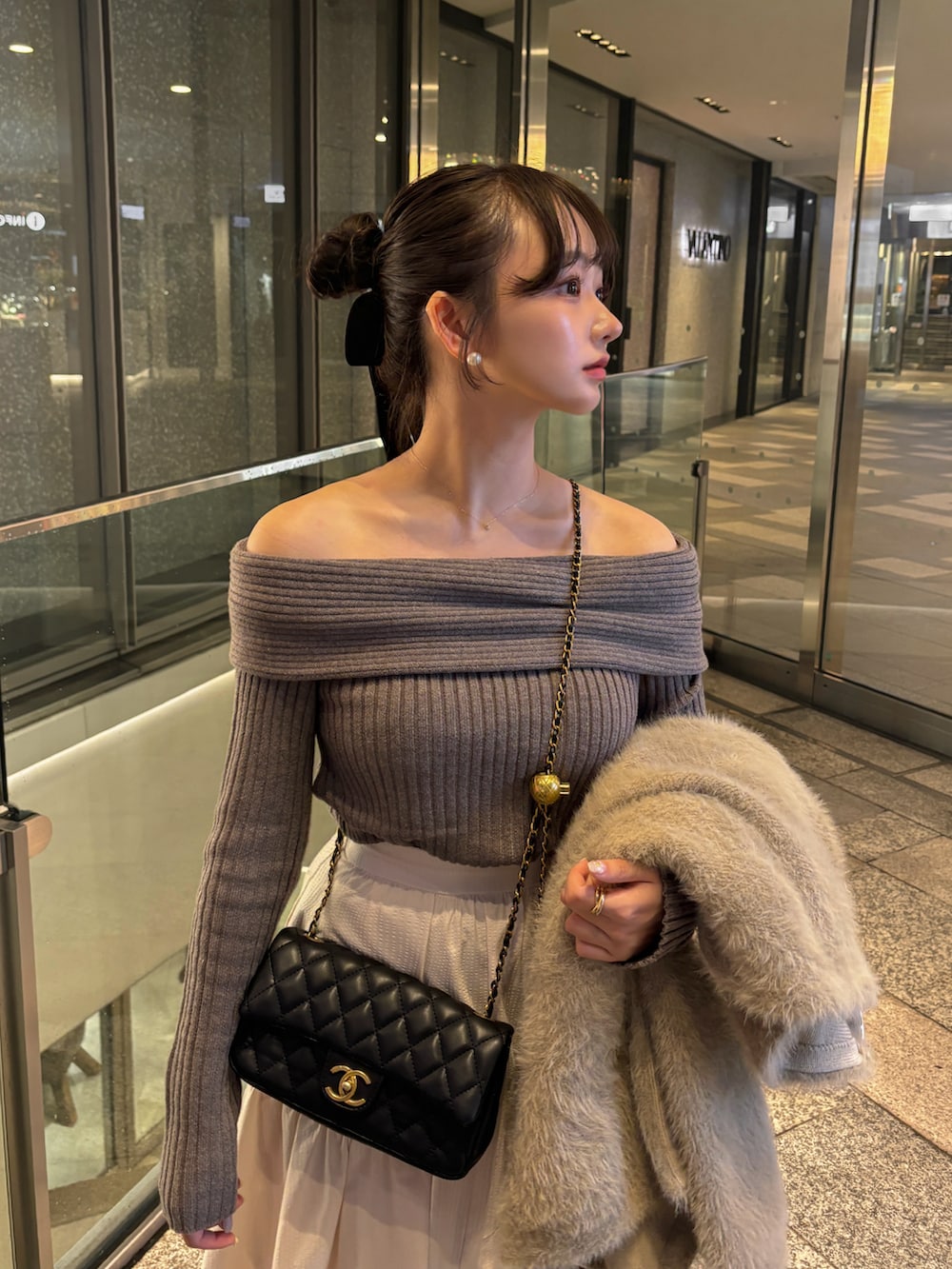 ホワイト系のスカート、ブラウン系のニット/セーター、ベージュ系のジャケット/アウターを着用したレディースの秋コーディネートの3枚目の写真