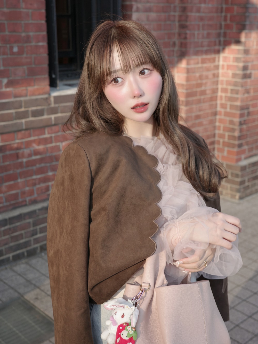 ブラウン系のジャケット/アウター、ピンク系のトップス、ブルー系のデニムパンツを着用したレディースの冬コーディネートの2枚目の写真