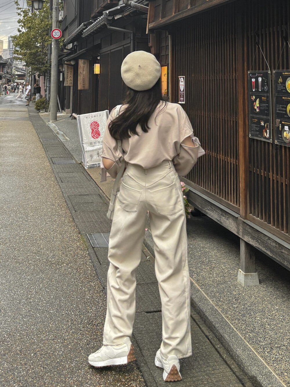 ホワイト系のスラックス、ホワイト系のスニーカー、ホワイト系のバッグを着用したレディースの秋コーディネートの5枚目の写真