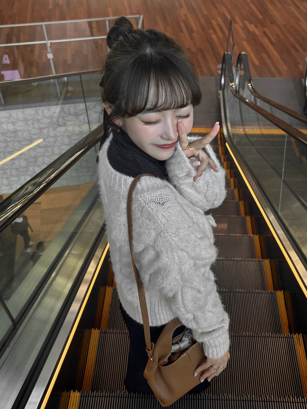 ホワイト系のニット/セーター、グレー系のトップス、ブラウン系のバッグを着用したレディースの秋コーディネートの3枚目の写真