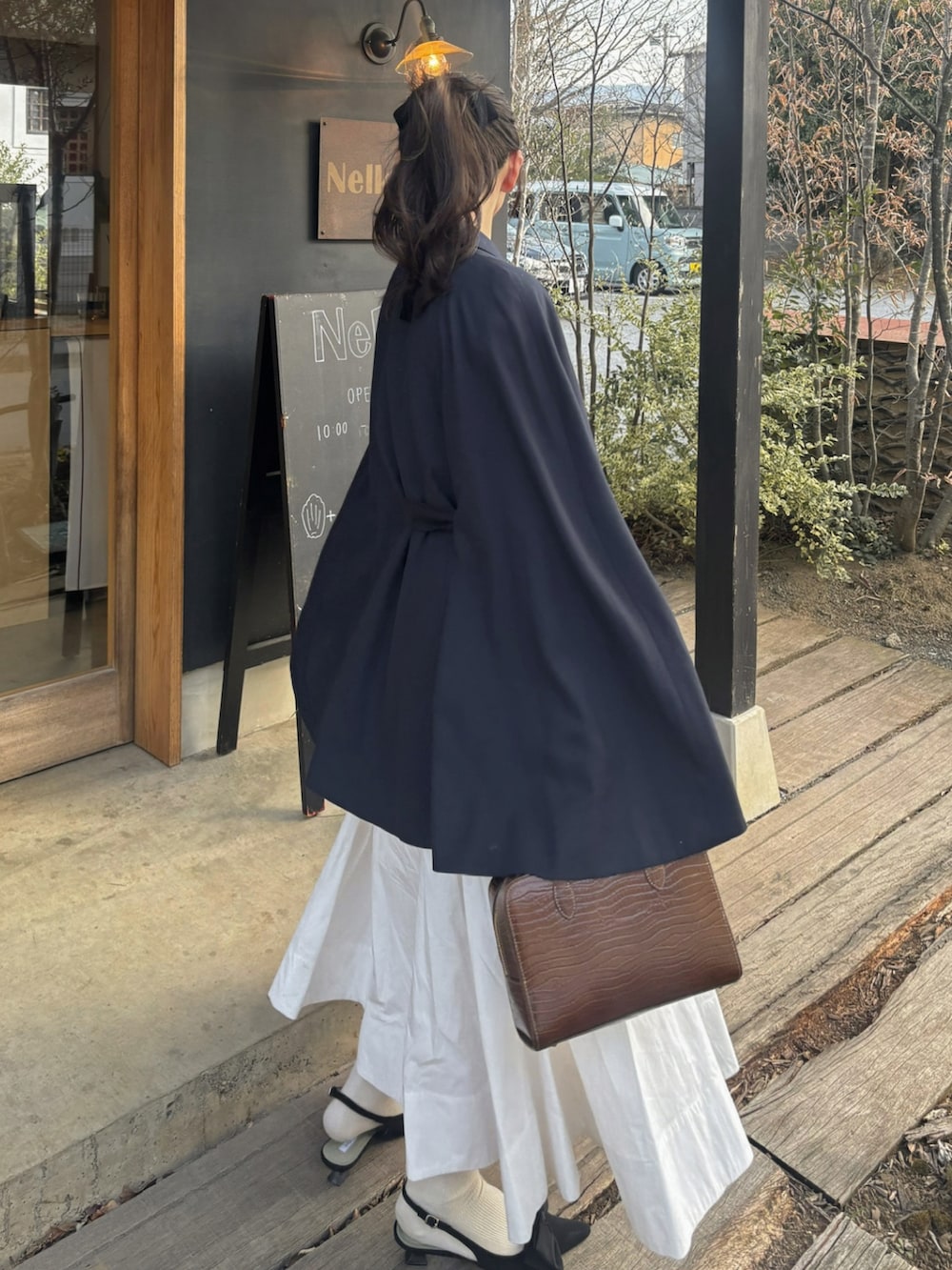 ブルー系のその他アウター、ホワイト系のスカート、ブラウン系のバッグを着用したレディースの春コーディネートの4枚目の写真