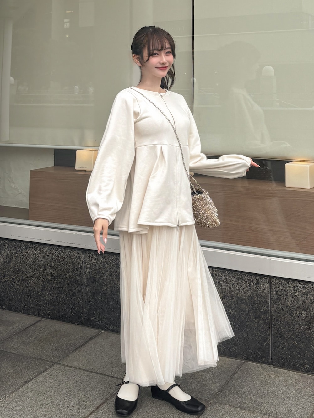 ブラック系のパンプス、ホワイト系のスカート、ホワイト系のスウェットを着用したレディースの春コーディネートの3枚目の写真