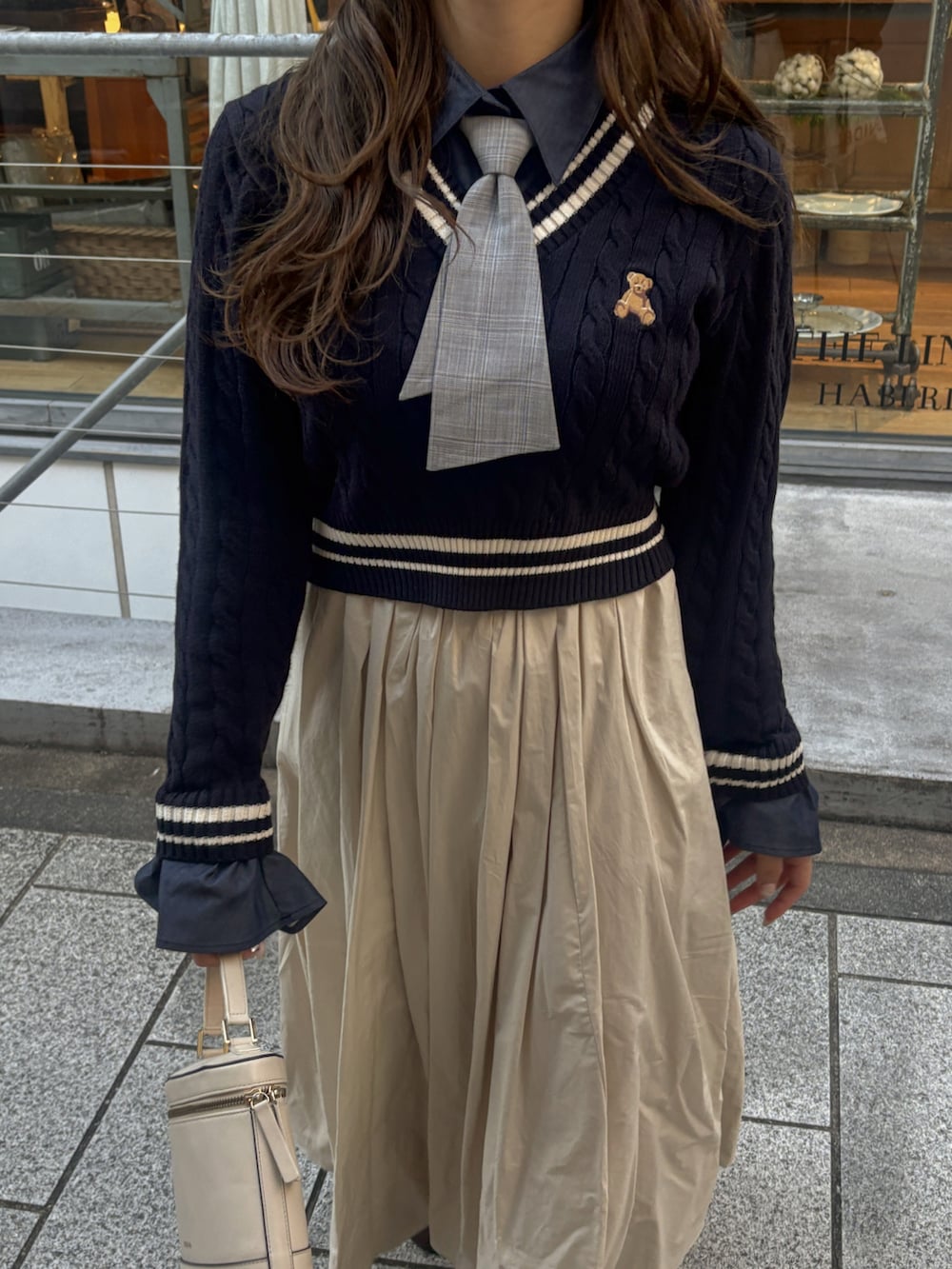 ブルー系のニット/セーター、ベージュ系のショルダーバッグ、ホワイト系のワンピースを着用したレディースの冬コーディネートの5枚目の写真