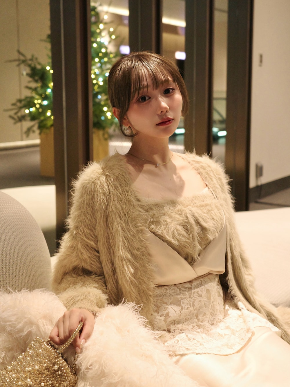 ホワイト系のワンピース/ドレス、ベージュ系のアンサンブル、ゴールド系のバッグを着用したレディースの秋コーディネートの3枚目の写真