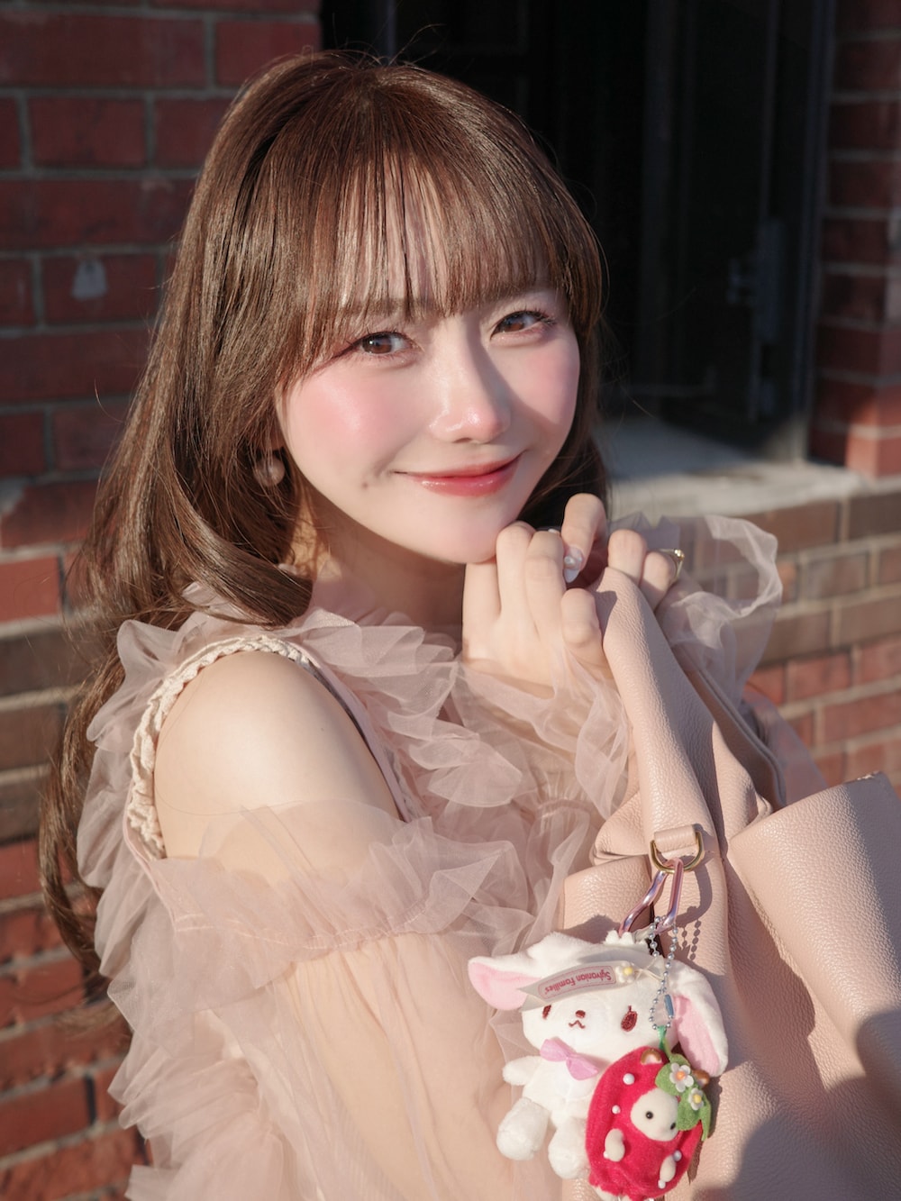 ブラウン系のジャケット/アウター、ピンク系のトップス、ブルー系のデニムパンツを着用したレディースの冬コーディネートの3枚目の写真