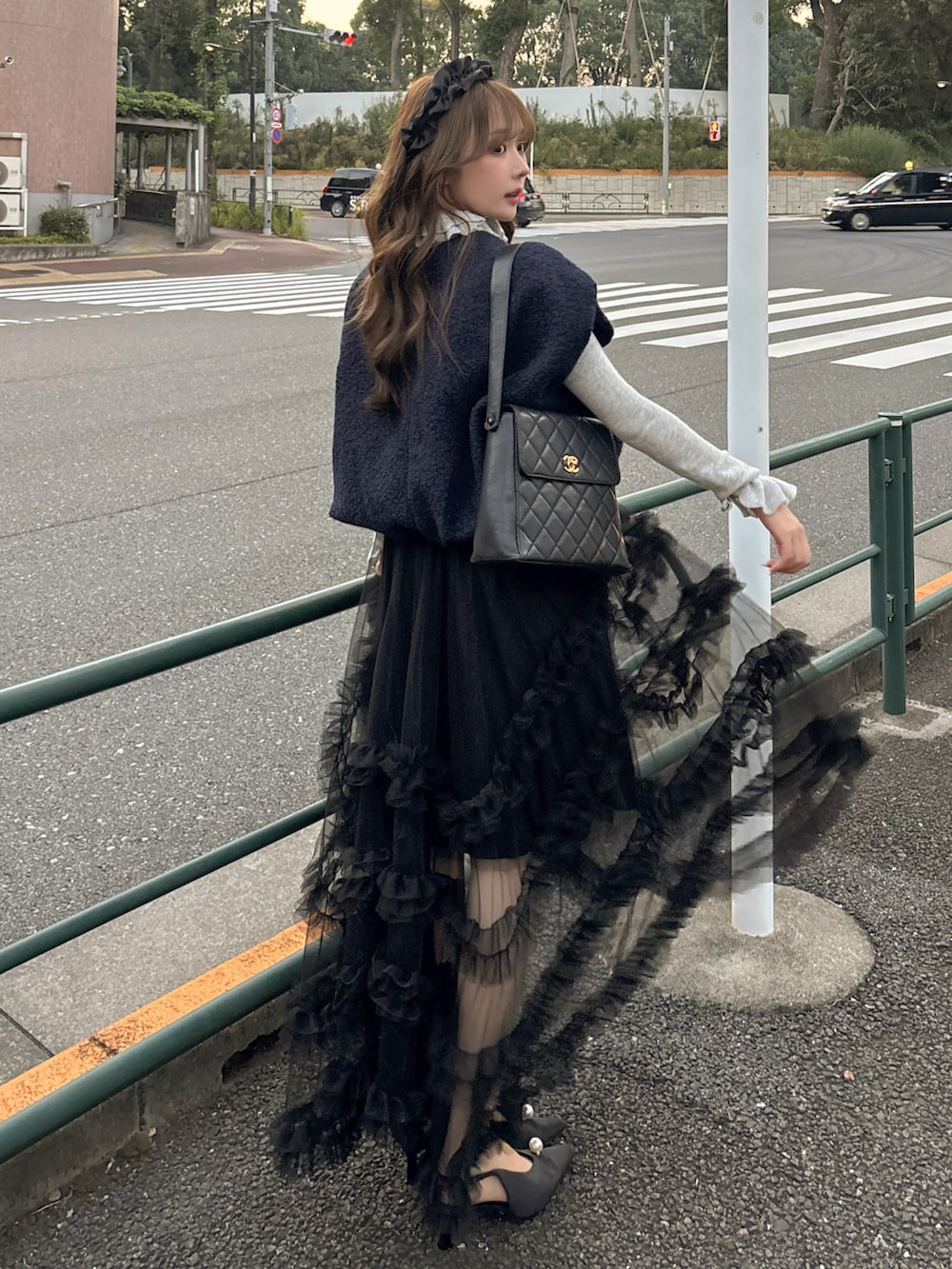 ブラック系のパンプス、ブルー系のトップス、ブラック系のスカートを着用したレディースの秋コーディネートの2枚目の写真