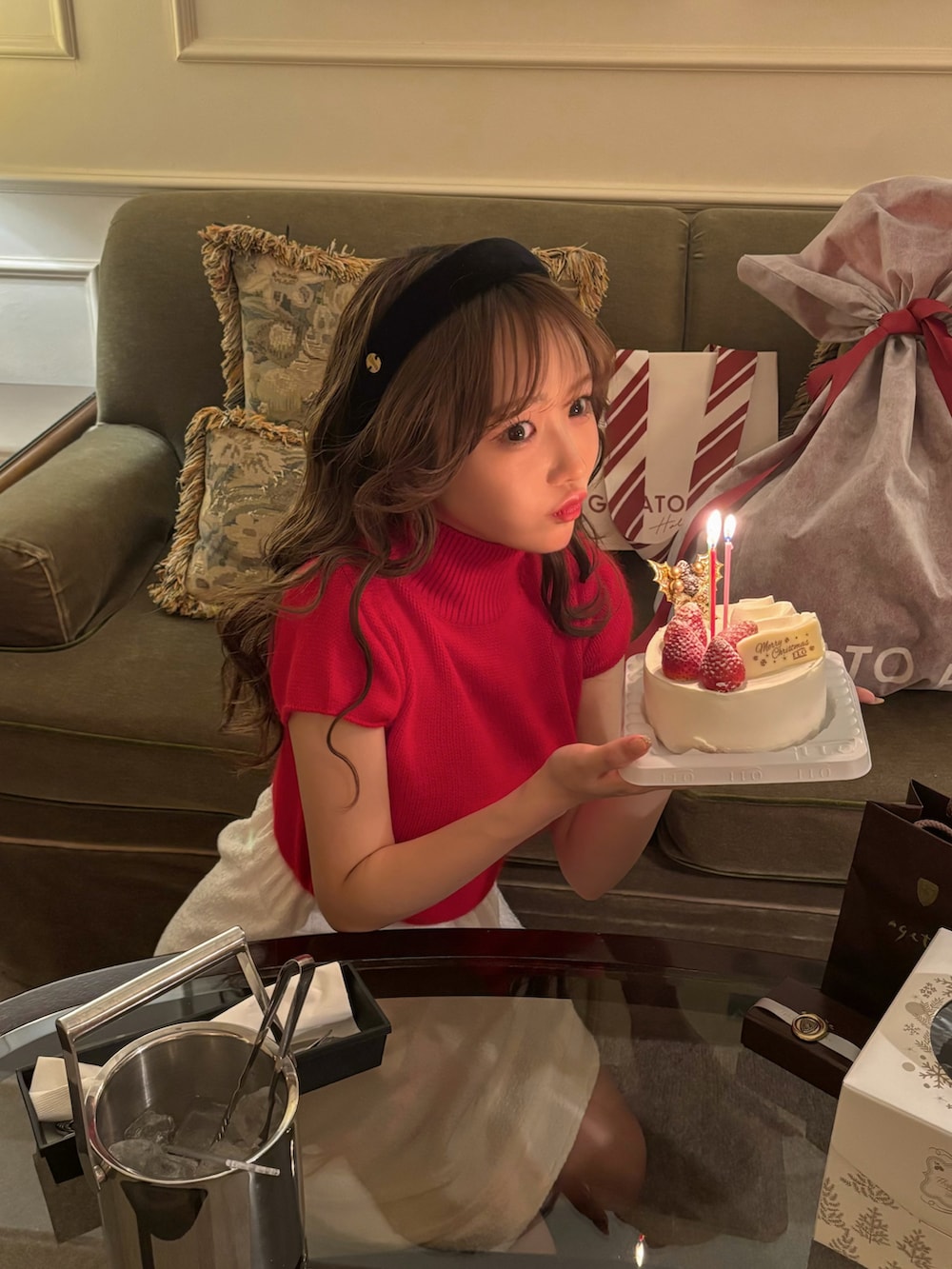 レッド系のトップス、ホワイト系のスカート、ブラウン系のブーツを着用したレディースの冬コーディネートの5枚目の写真