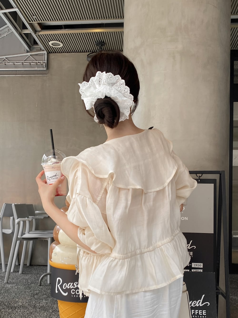 ピンク系のタンクトップ、ベージュ系のショルダーバッグ、ホワイト系のブルゾンを着用したレディースの夏コーディネートの2枚目の写真
