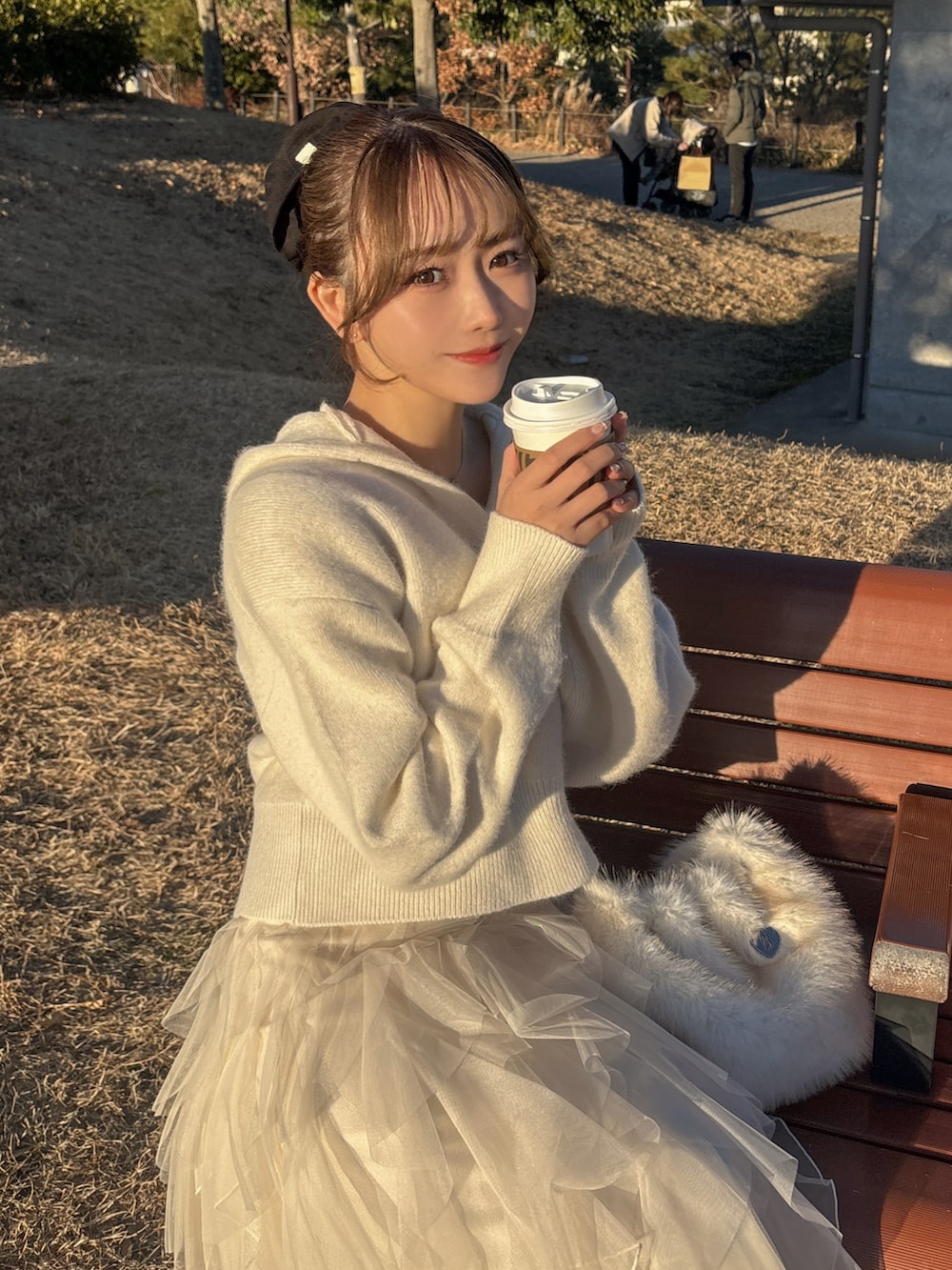 ホワイト系のニット/セーター、ホワイト系のスカート、ブラック系のブーツを着用したレディースの冬コーディネートの2枚目の写真