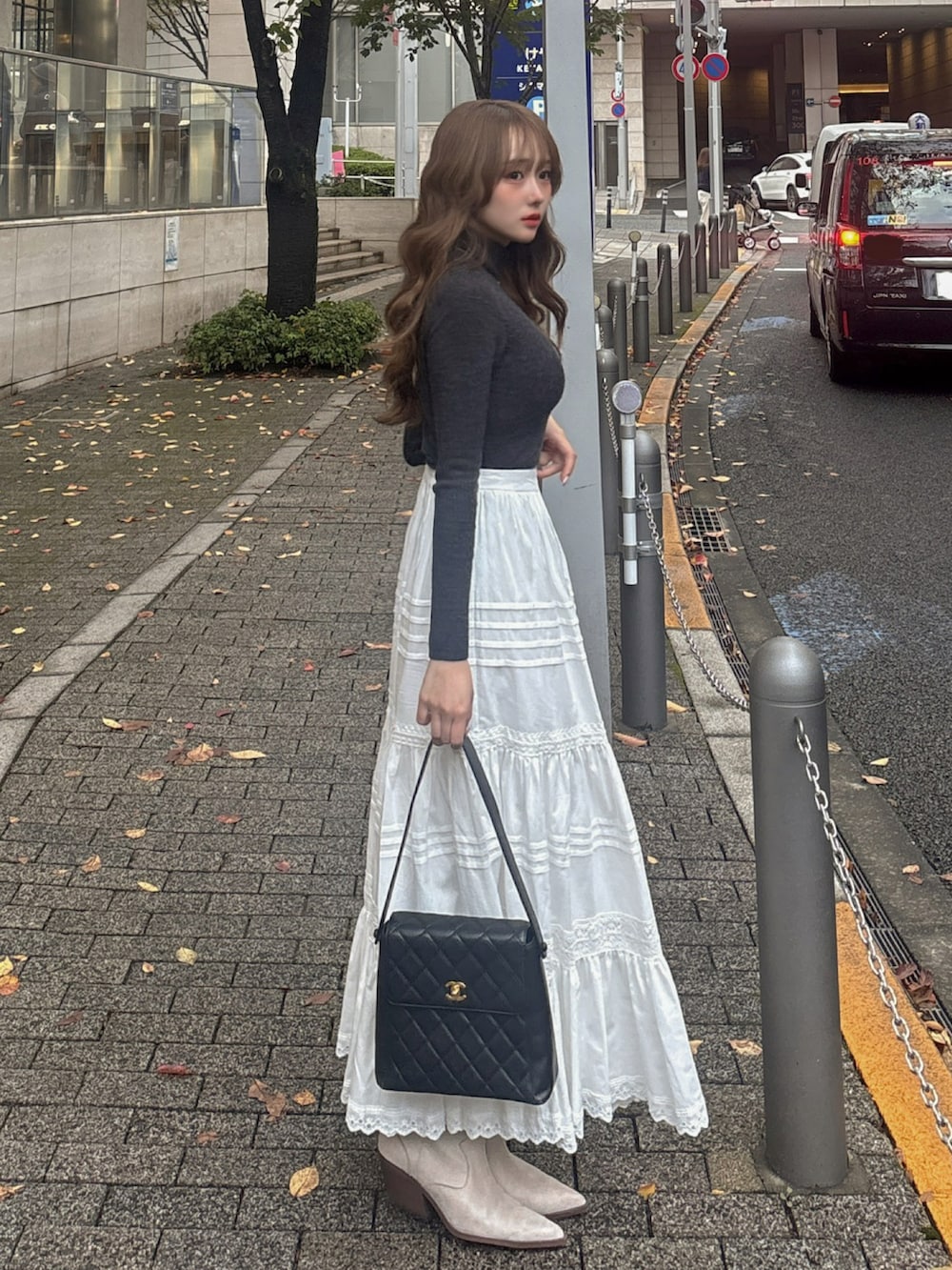 ブラック系のバッグ、ベージュ系のブーツ、グレー系のその他アウターを着用したレディースの秋コーディネートの2枚目の写真