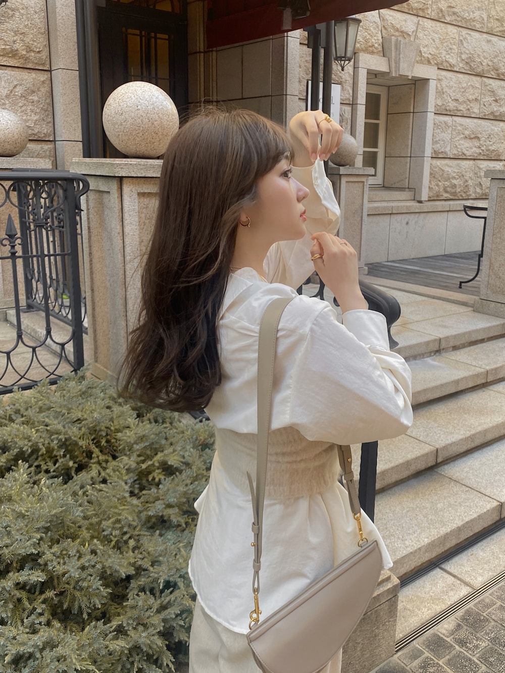 ホワイト系のスニーカー、ベージュ系のパンツ、ホワイト系のニット/セーターを着用したレディースの秋コーディネートの3枚目の写真