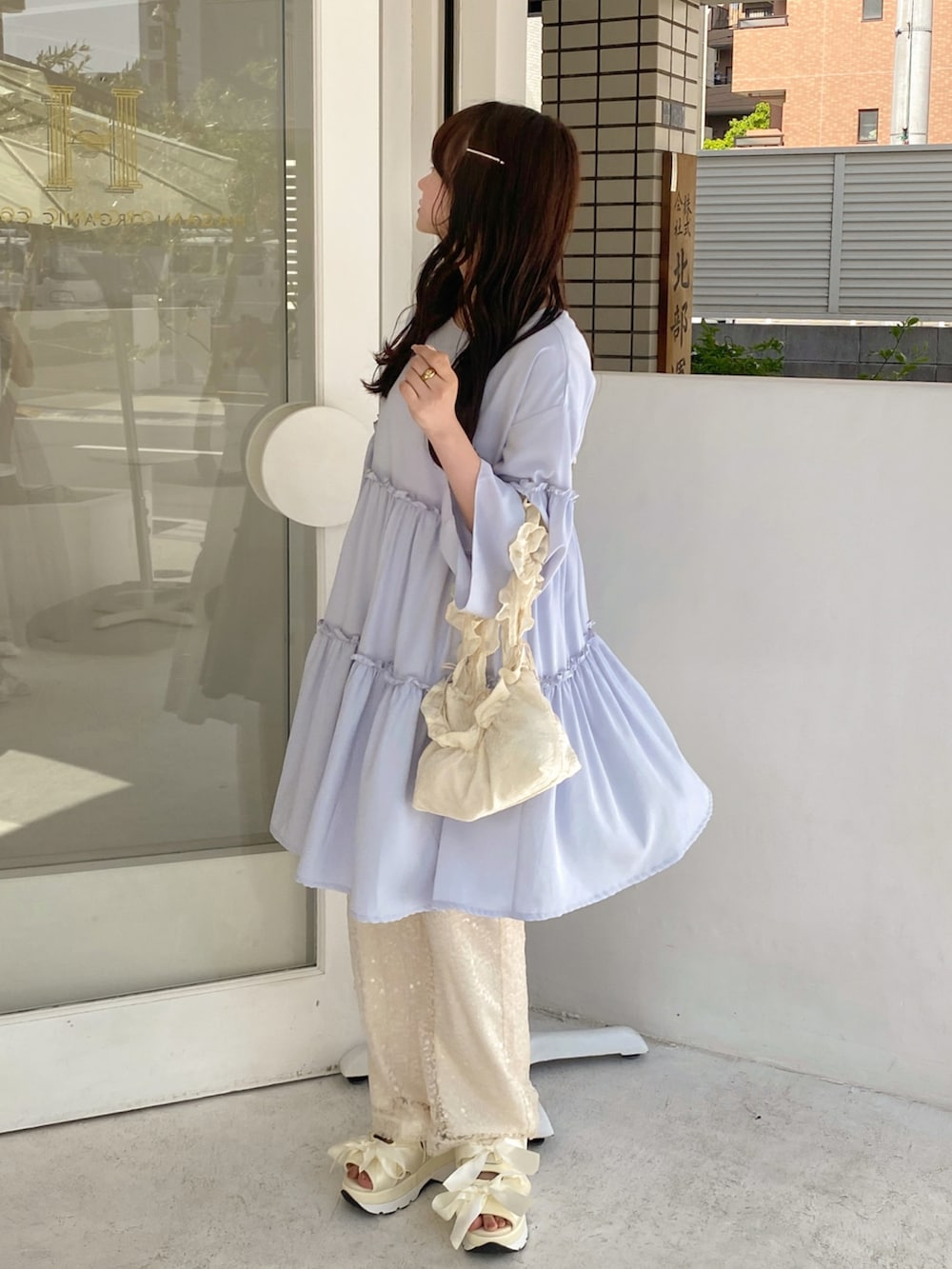 ブルー系のワンピース、ホワイト系のハンドバッグ、ホワイト系のその他パンツを着用したレディースの春コーディネートの4枚目の写真