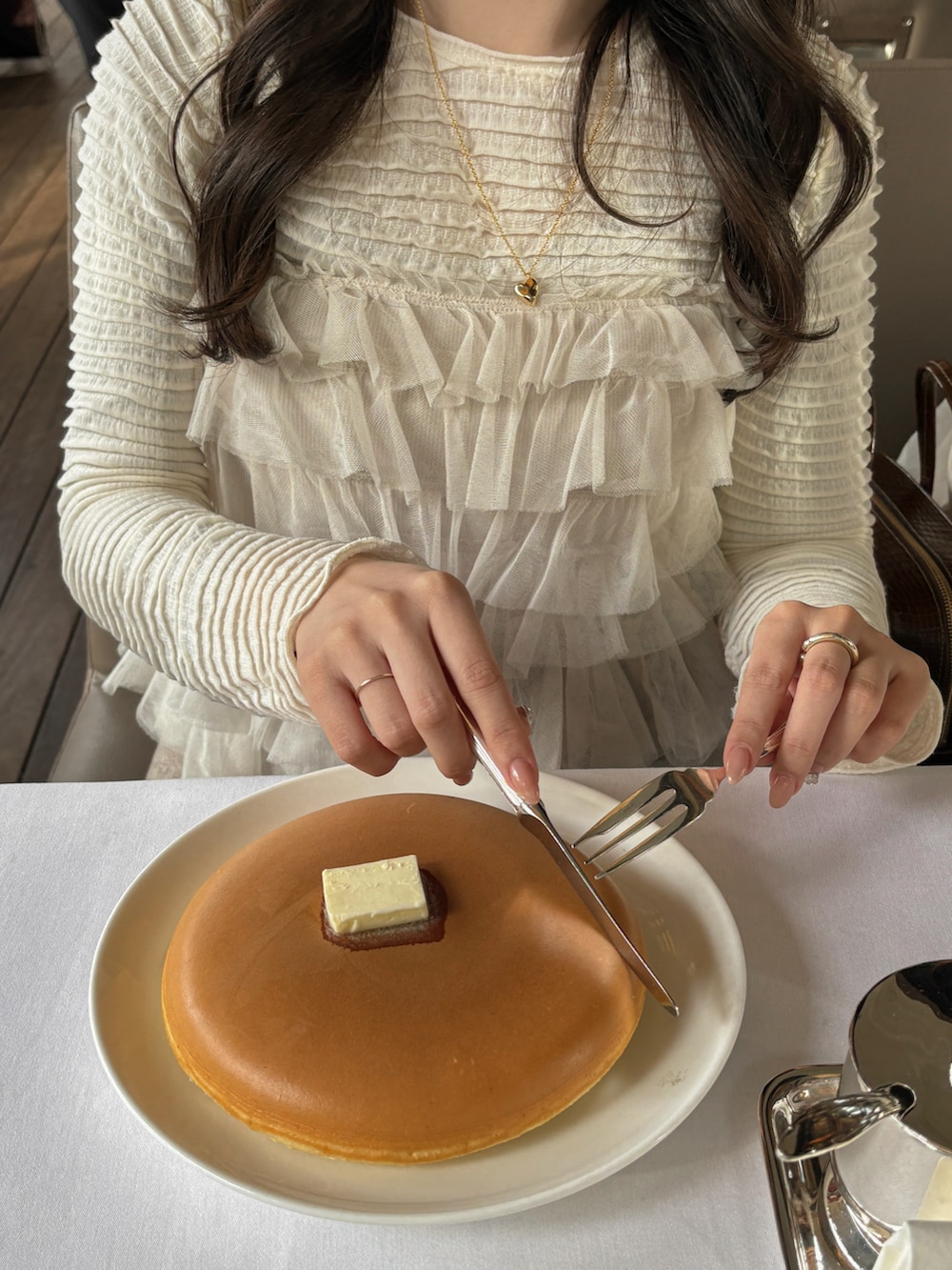 ホワイト系のTシャツ/カットソー、ホワイト系のトップス、ブラウン系のスカートを着用したレディースの冬コーディネートの3枚目の写真