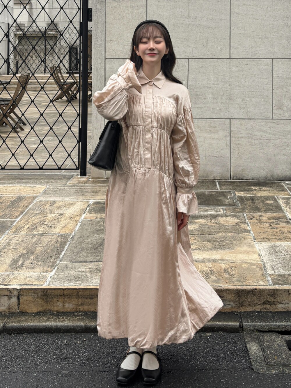 ピンク系のワンピース、ブラック系のバッグ、ブラック系のパンプスを着用したレディースの冬コーディネートの2枚目の写真