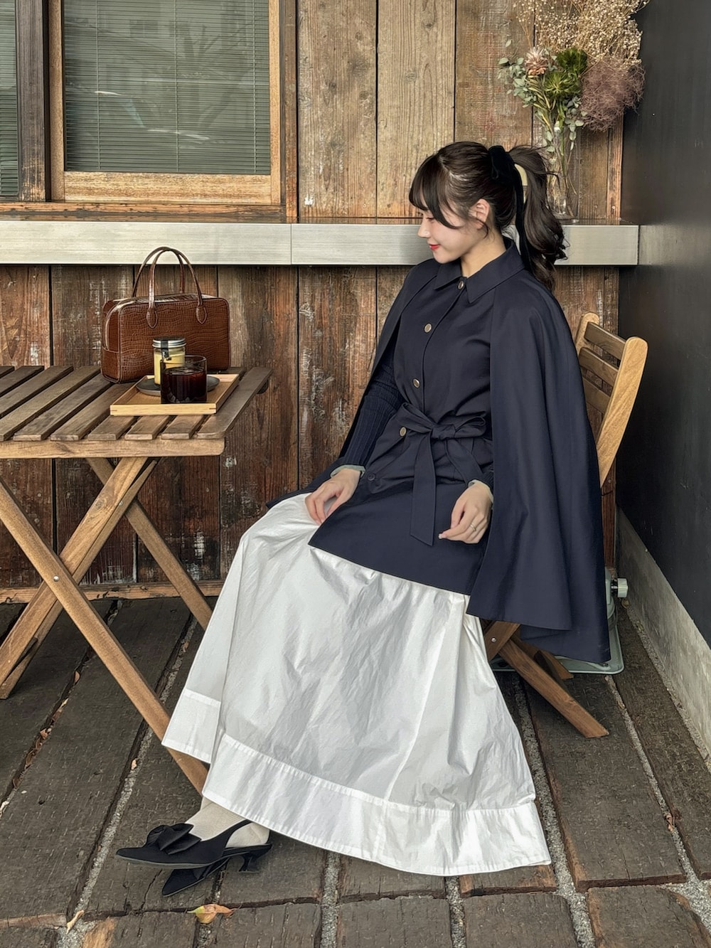 ブルー系のその他アウター、ホワイト系のスカート、ブラウン系のバッグを着用したレディースの春コーディネートの5枚目の写真