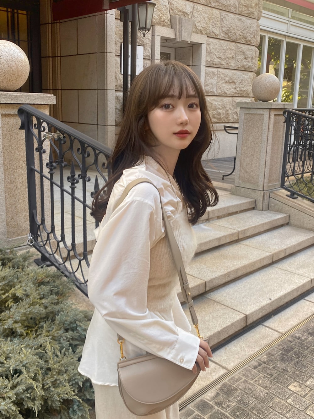 ホワイト系のスニーカー、ベージュ系のパンツ、ホワイト系のニット/セーターを着用したレディースの秋コーディネートの4枚目の写真