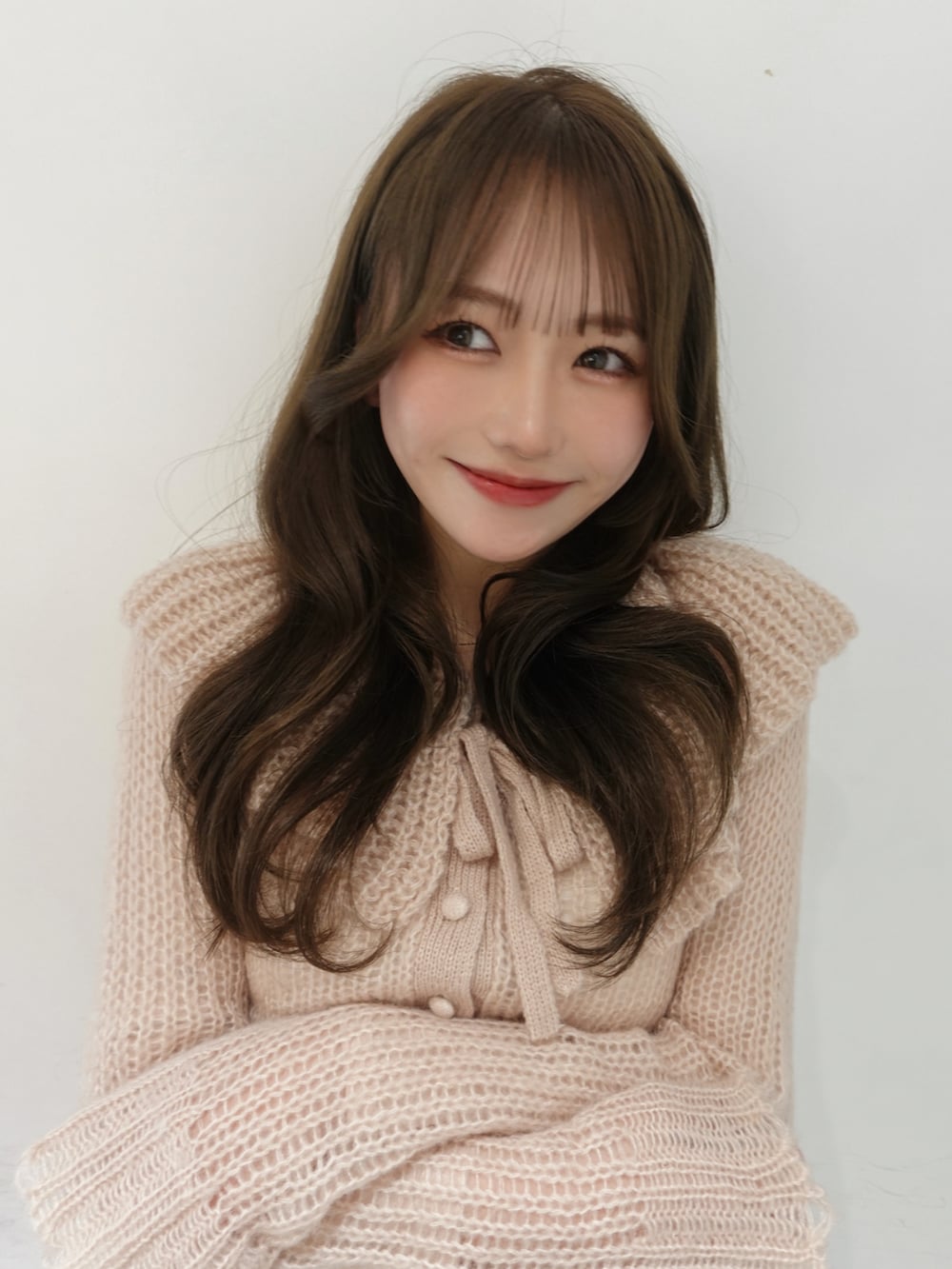 ベージュ系のブーツ、ピンク系のニット/セーター、ホワイト系のスラックスを着用したレディースの春コーディネートの4枚目の写真